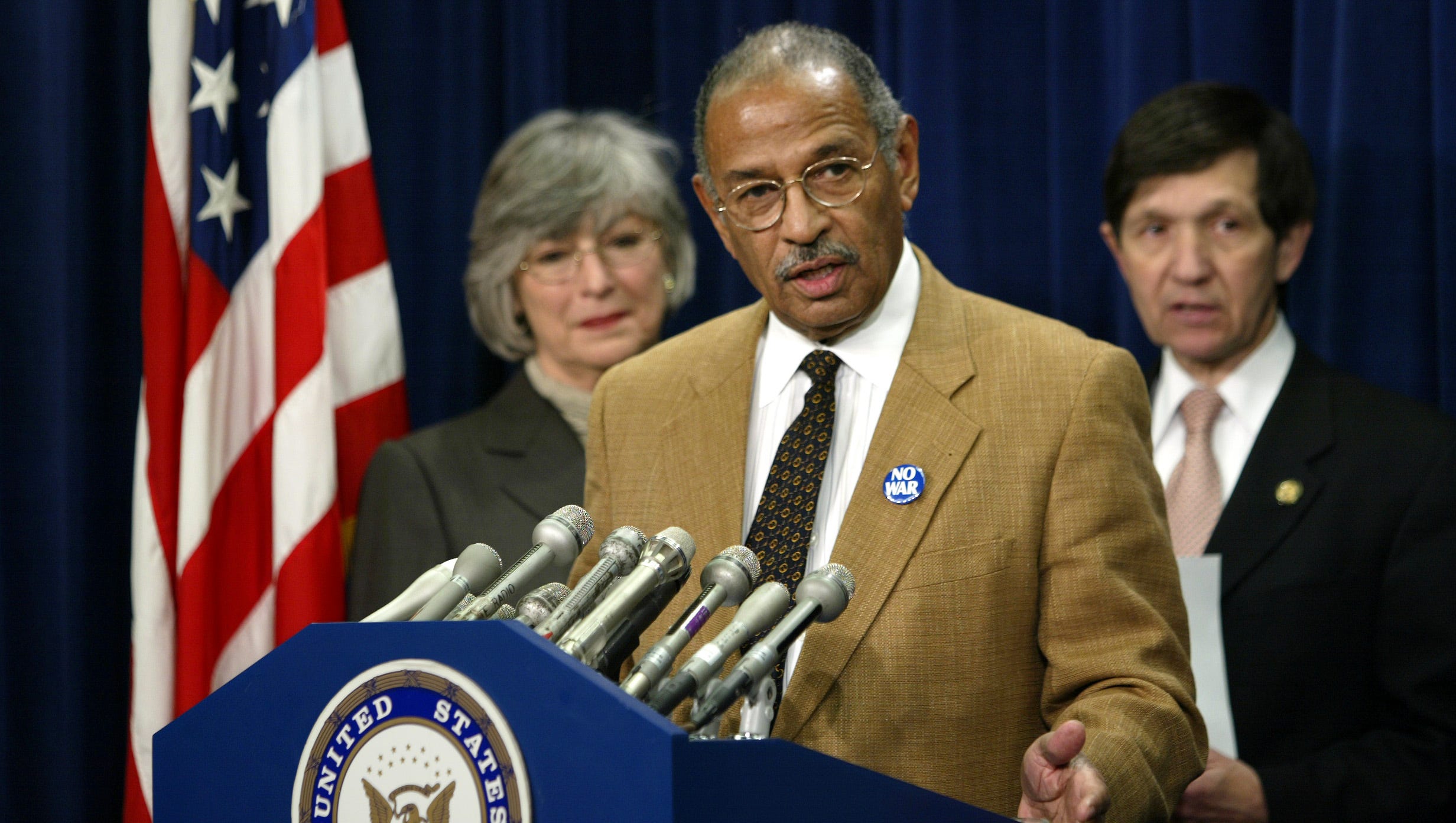 Conyers voices his concern about President George W. Bush's posture toward Iraq, as he speaks to reporters on Capitol Hill, Dec. 9, 2002. He is joined by Rep. Lynn C. Woolsey, D-Calif., left, and Rep. Dennis J. Kucinich, D-Ohio, at right.  Seven Democrats expressed worries that the Bush administration was intent on going to war without giving the inspections a chance to work.