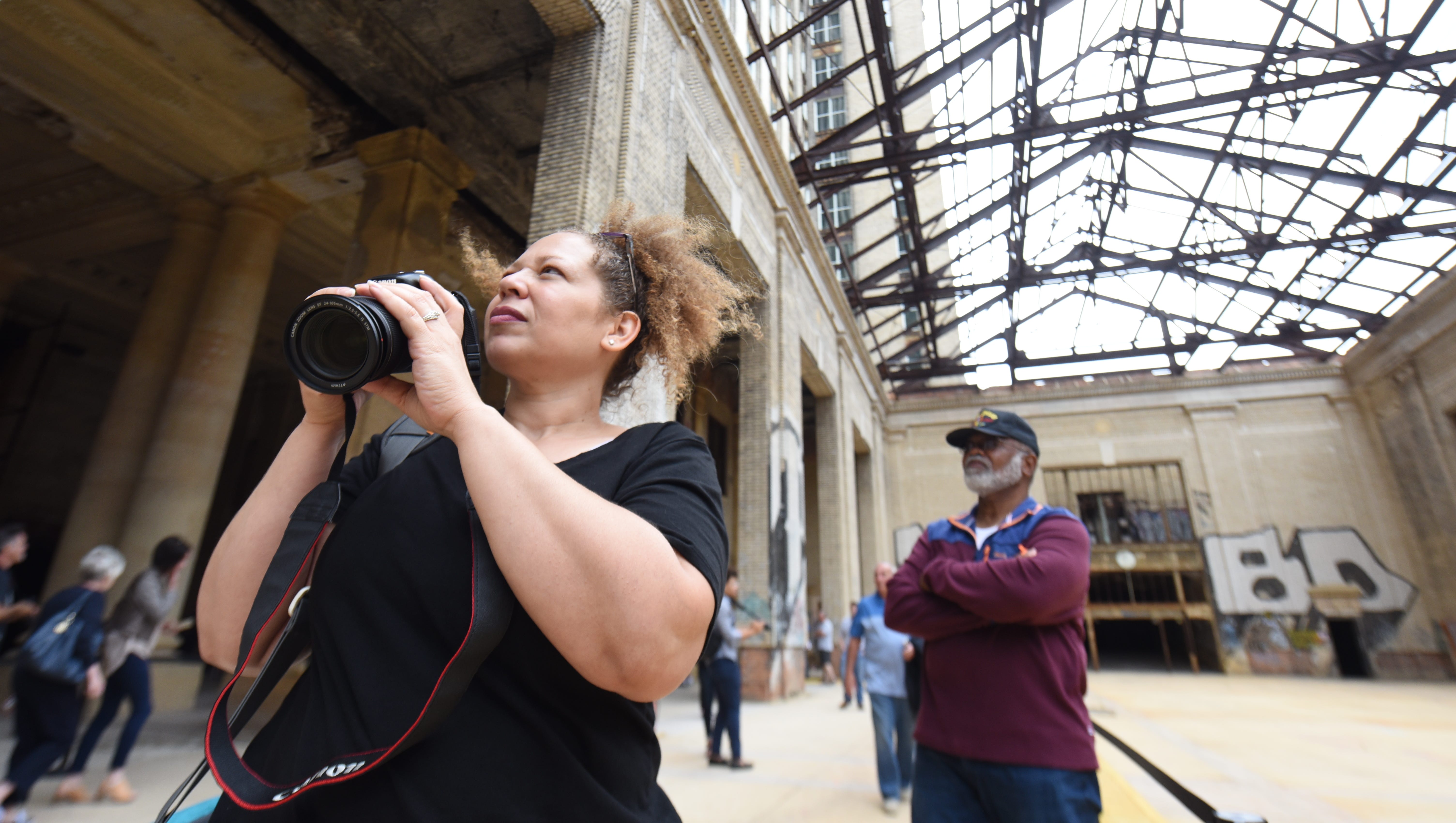 Tara Carter takes photos of the concourse area of the Michigan Central Train depot along with her father, Gary Miller of Rochester, during a public tour on Friday.