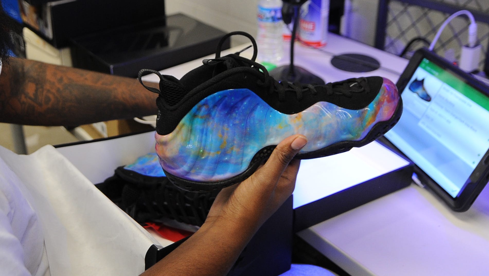Aaron Fields, senior authenticator at StockX,  inspects a pair of Nike Air Formposite One shoes.