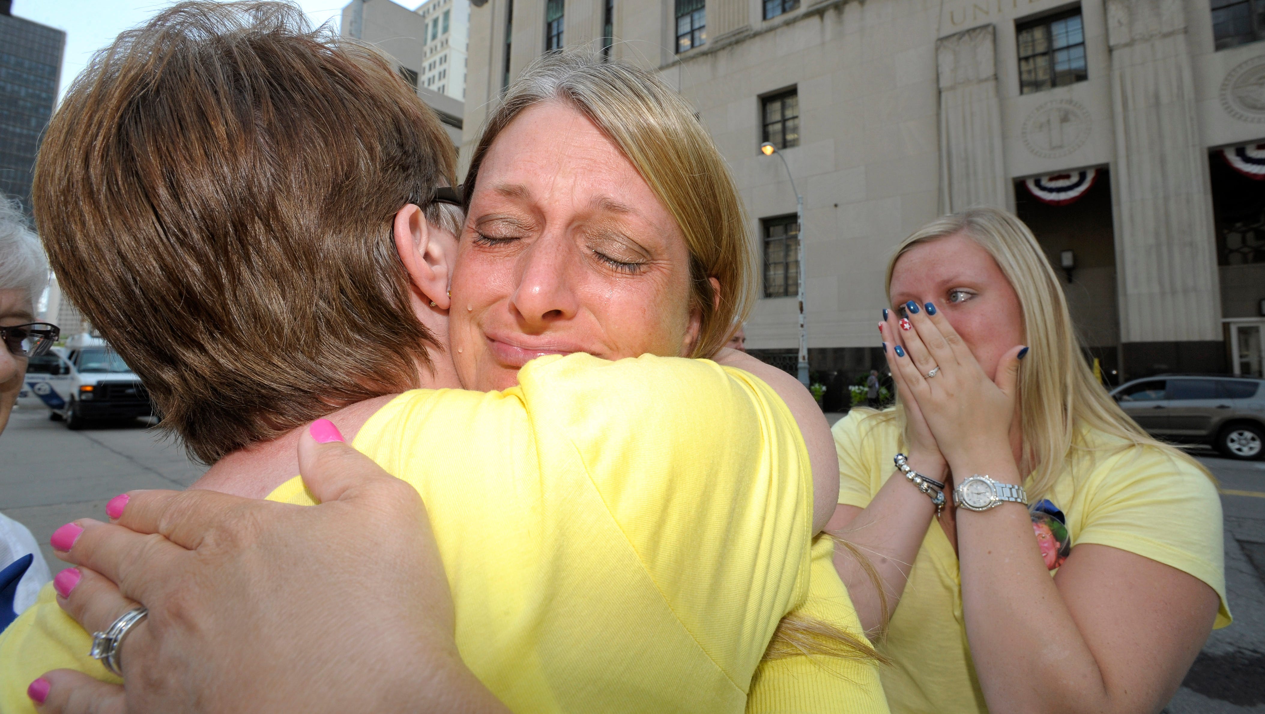 Geraldine Parkin, left, 54, of Davison, whose husband, Tim, is still alive after being overtreated by Farid Fata, hugs Cheryl Blades, center, whose mother, Nancy LaFrance, died of lung cancer. Blades daughter and LaFrance's granddaughter, Jessica Blades, right, 25, both of Waterford, also cries. Family members of victims express emotion as they leave the federal courthouse in Detroit, Friday afternoon, July 10, 2015, after they listen to the 45-year sentencing of Dr. Farid Fata for misdiagnosis of cancer and Medicare fraud.