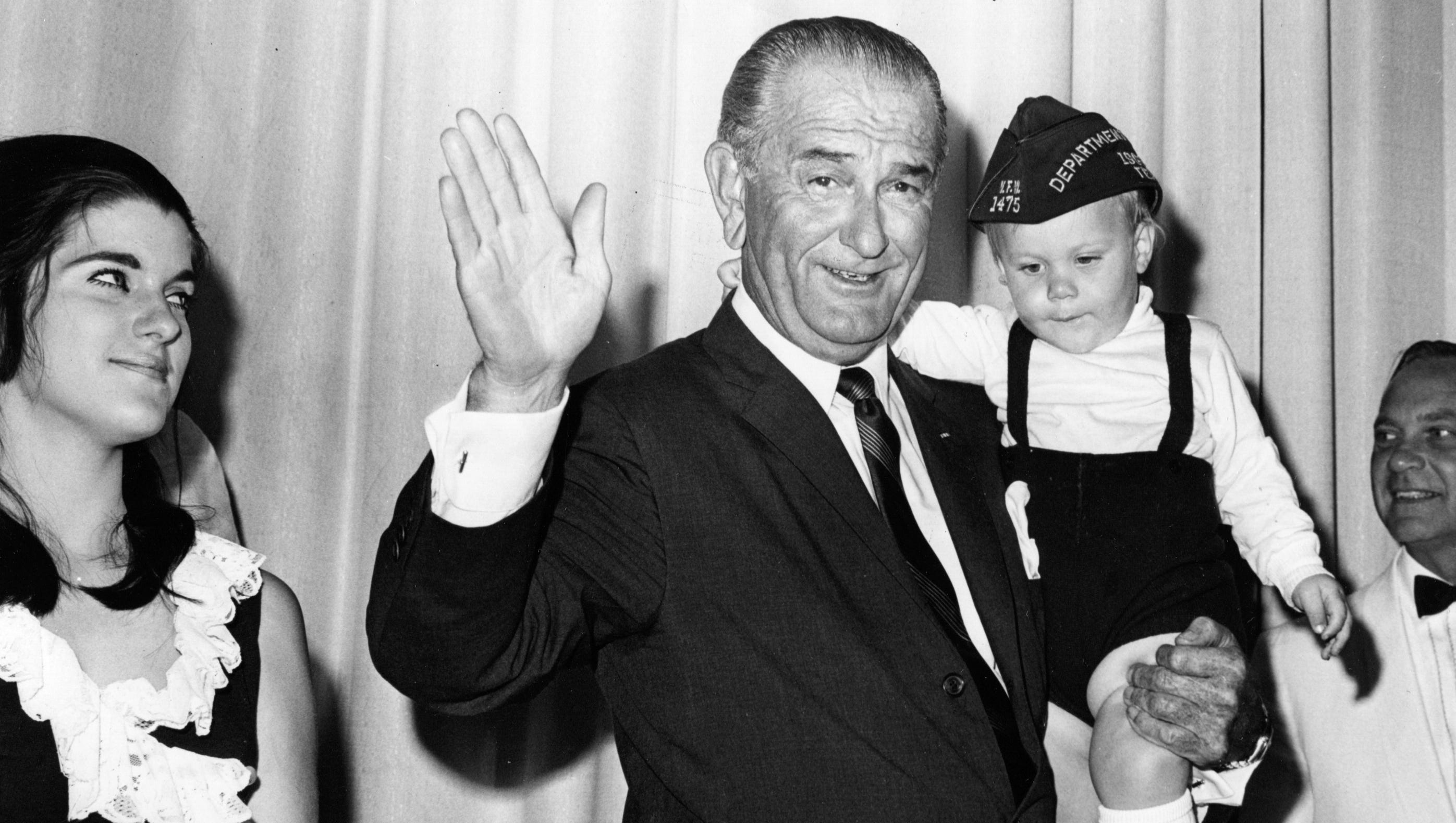 President Lyndon B. Johnson attends the VFW convention on Aug. 21, 1968. Daughter Luci Nugent is at left, and the president is holding his grandson Pat Nugent Jr.