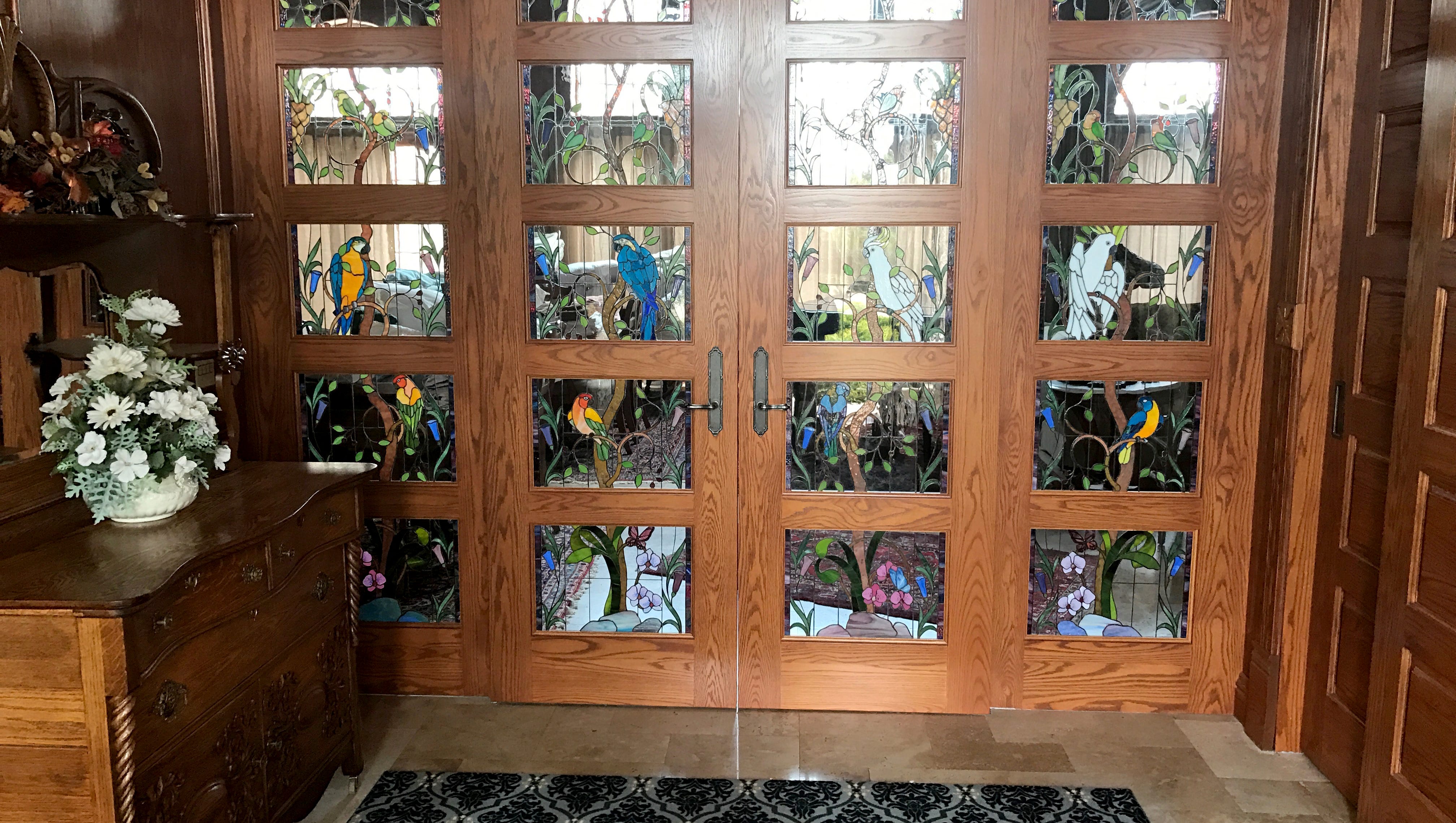 Stained glass windows of birds and foliage adorn the front doors.