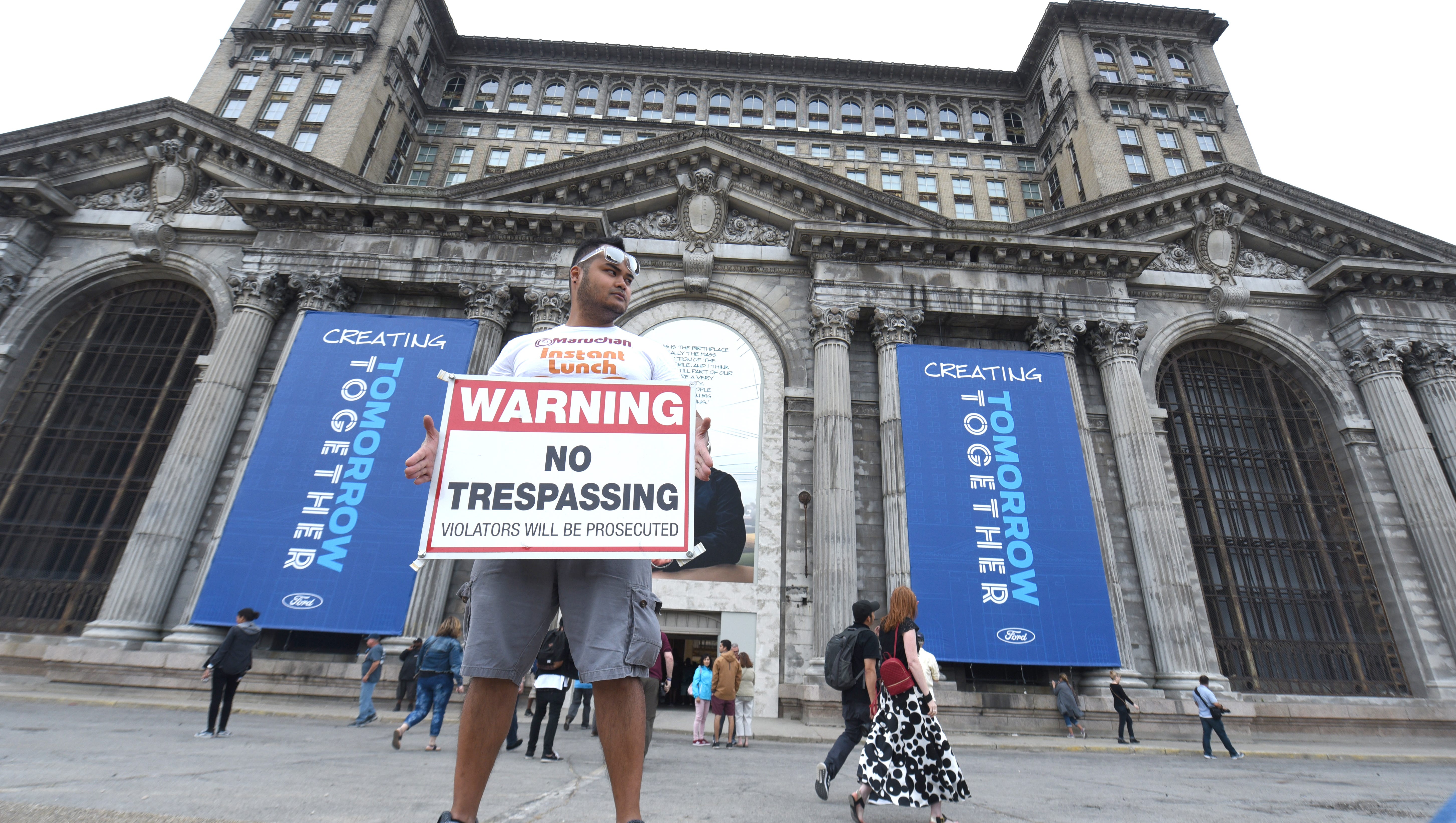 Francis Fiel of Dearborn holds a No Trespassing sign during an open house for the Michigan Central Train Depot on Friday June 22, 2018. Fiel remembers the many times he would explore the famed station despite such warnings to photograph the urban ruin.