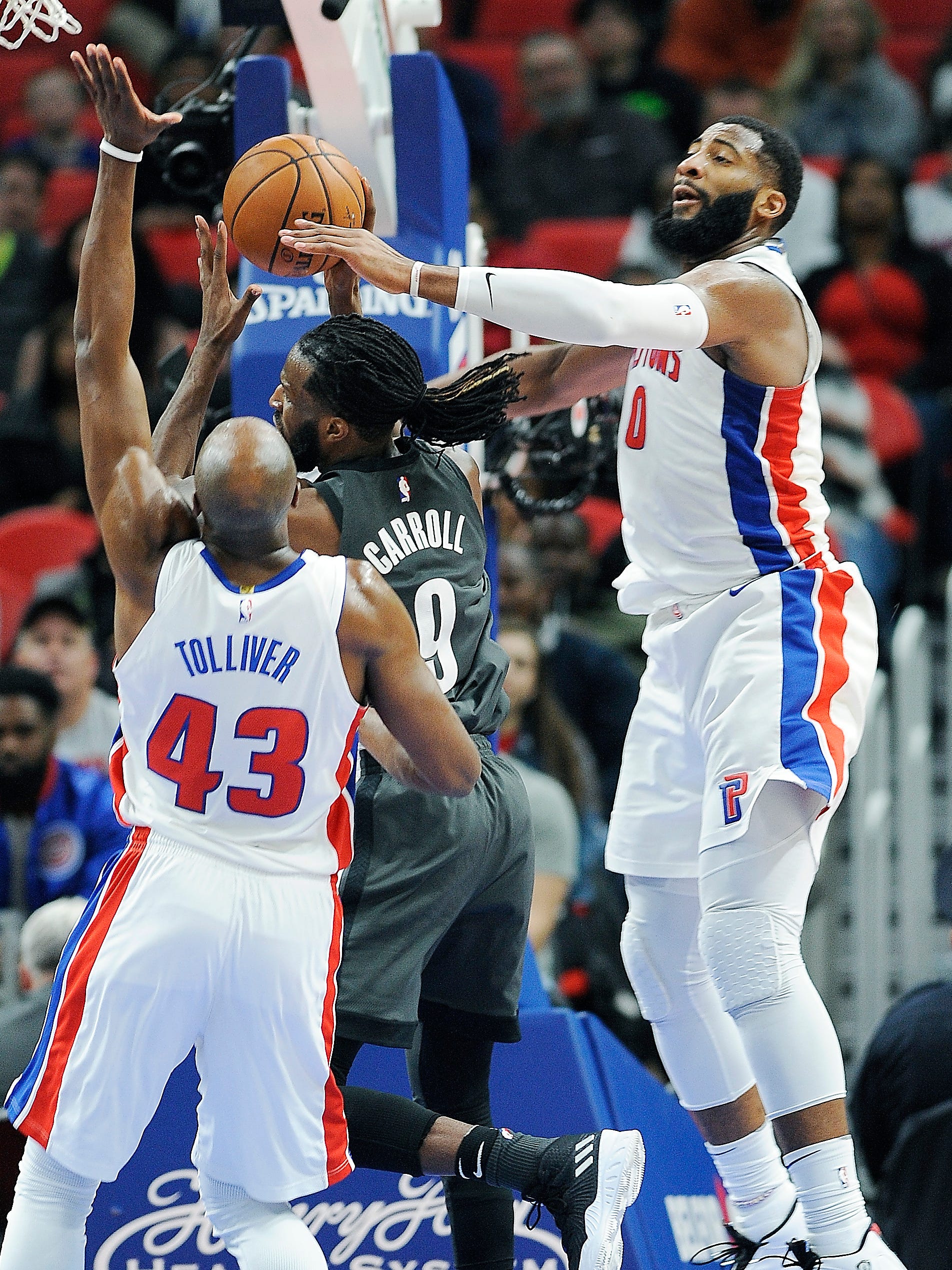 Anthony Tolliver, left; and Andre Drummond defend Nets' DeMarre Carroll in the third quarter.