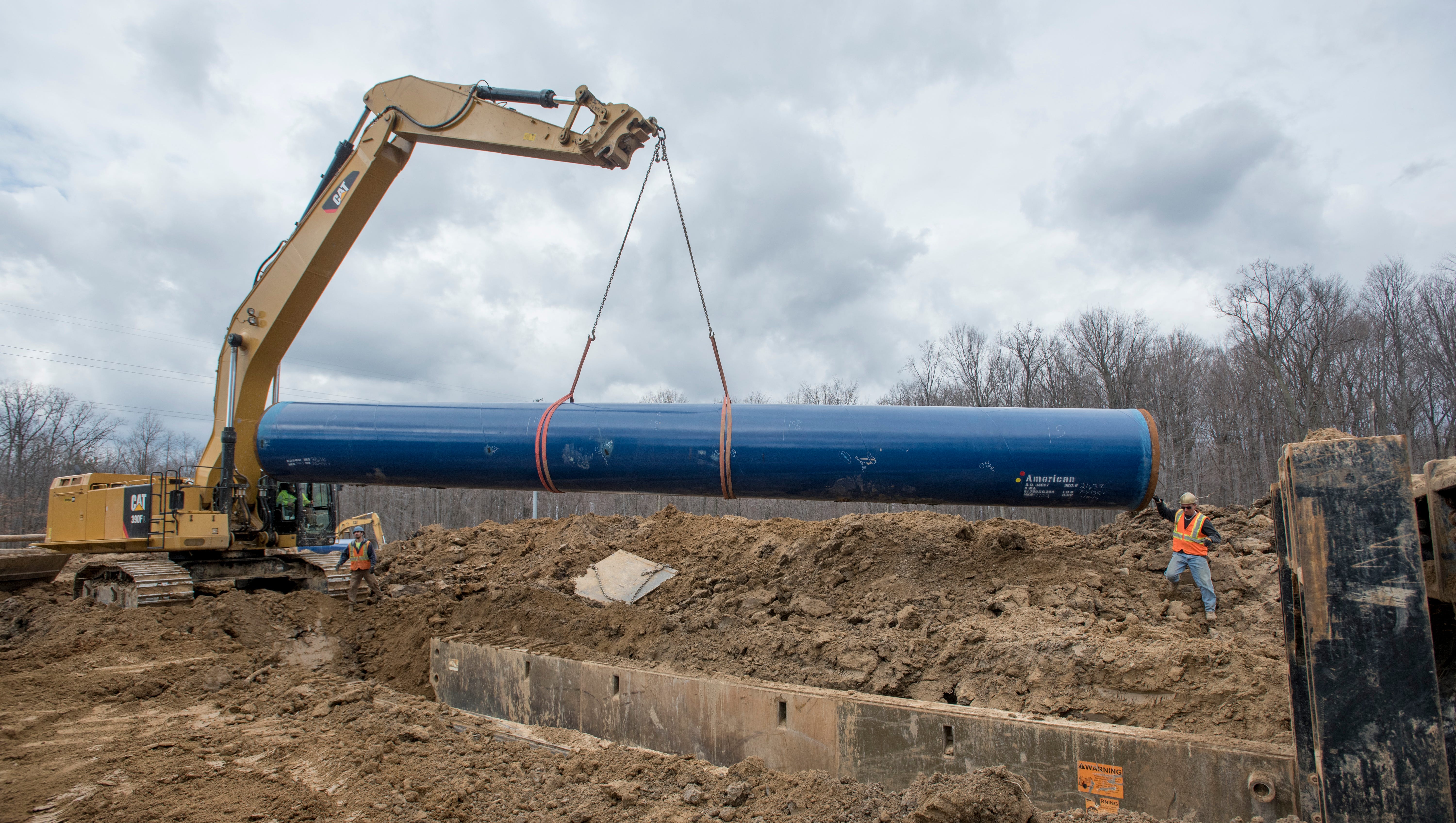 Laborers work on inserting a 50-foot section of the Karegnondi Water Authority pipeline.