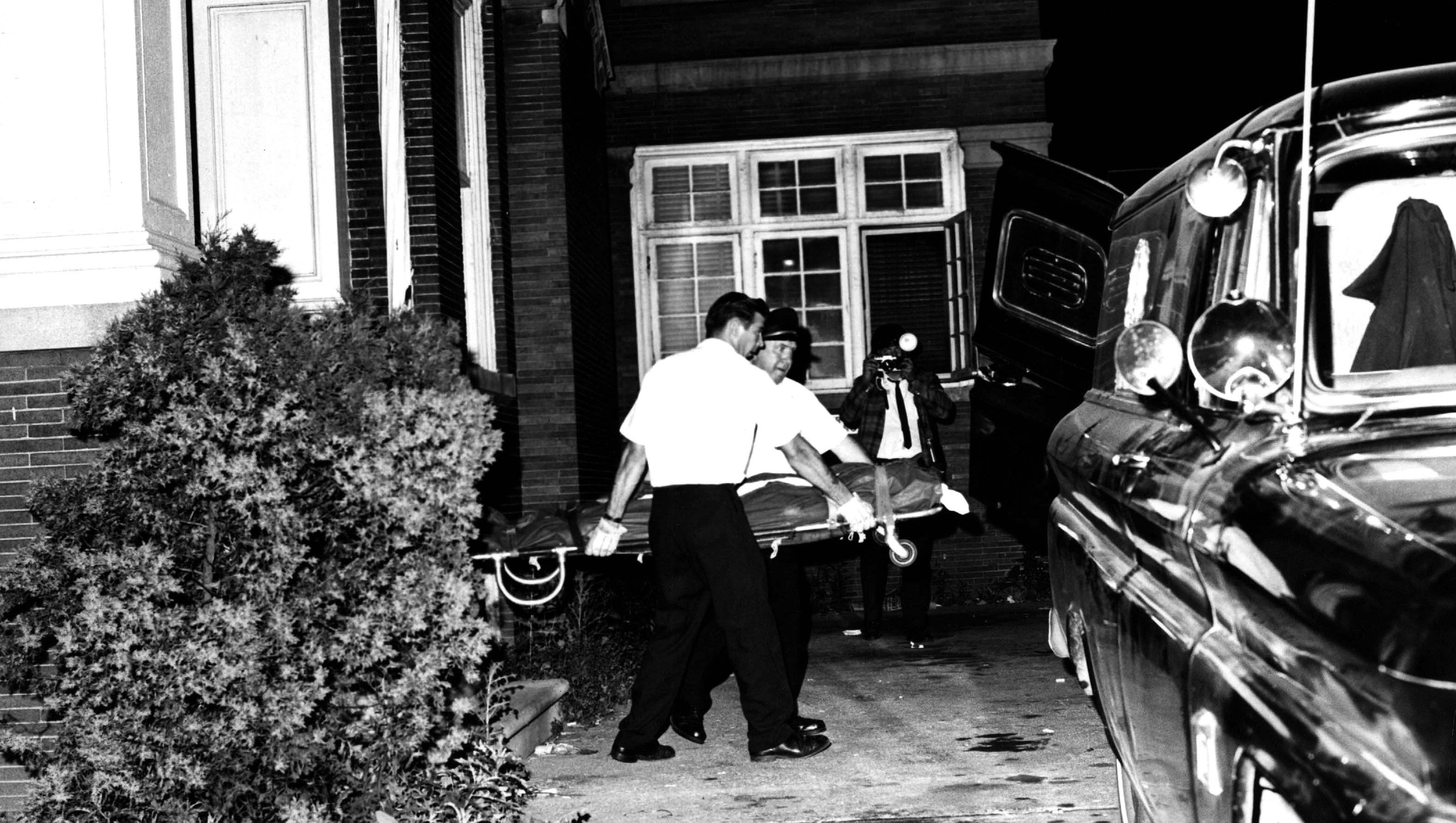 Emergency workers remove a body from the Algiers Manor, the annex of the Algiers Motel. The men charged in the killings  also were accused of brutally beating seven other black men, and stripping and beating two white women, in the raid.