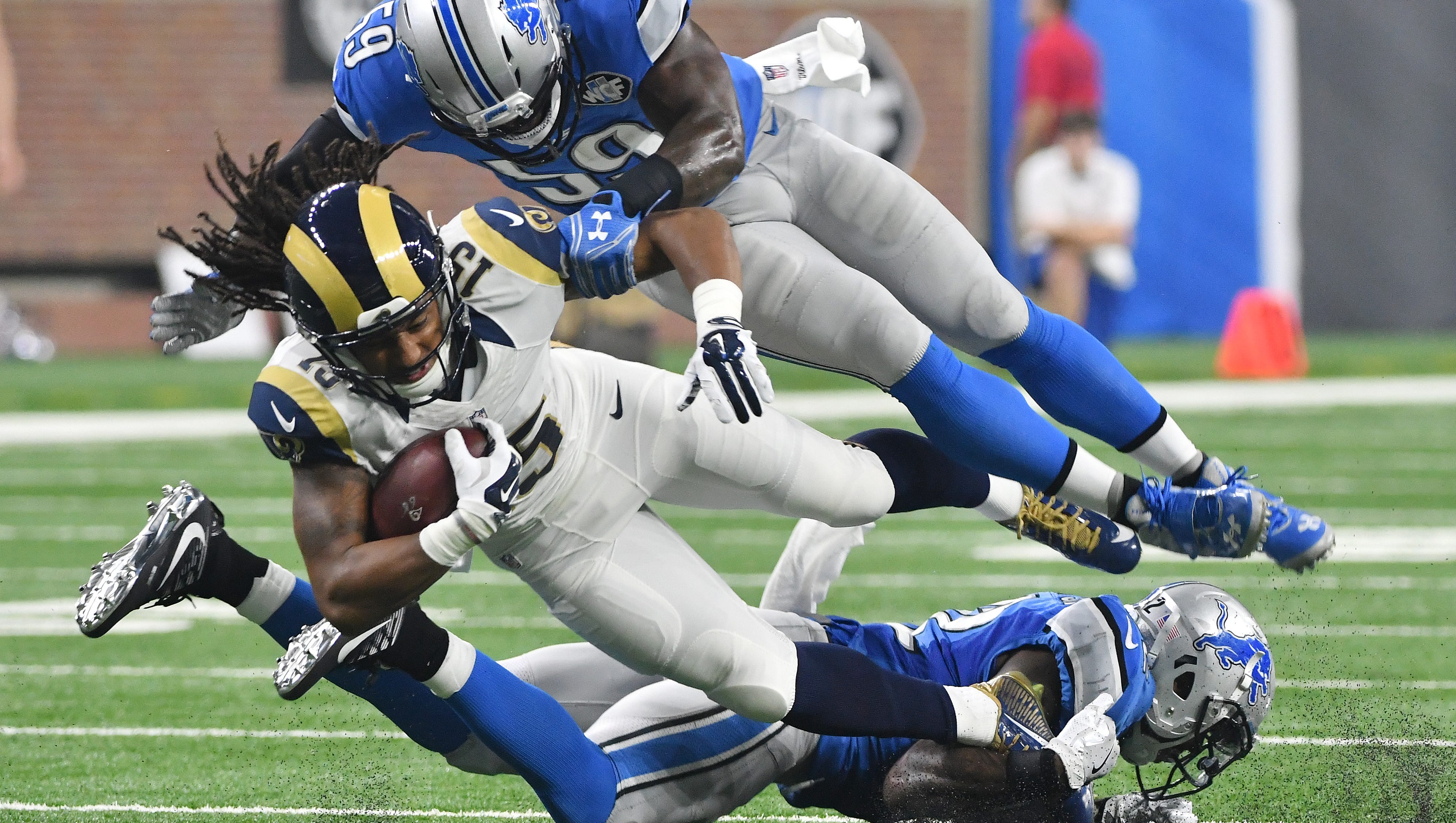 Lions defenders Tahir Whitehead and Tavon Wilson bring down the Rams' Bradley Marquez in the second quarter on Sunday.