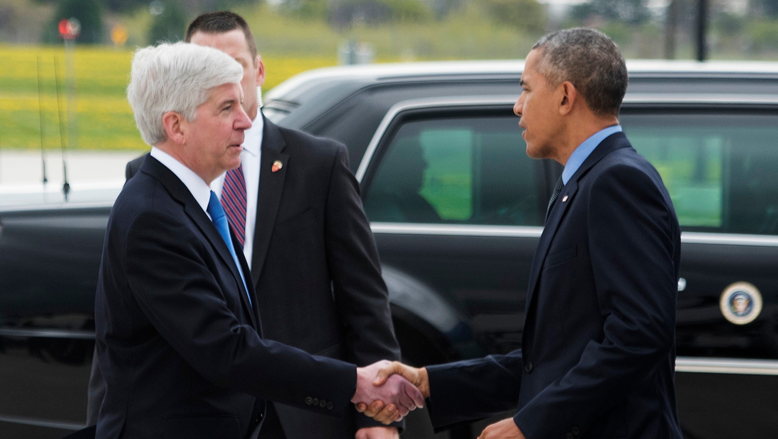 Michigan Gov. Rick Snyder greets President Barack Obama as he arrives to Bishop International Airport in Air Force One.
