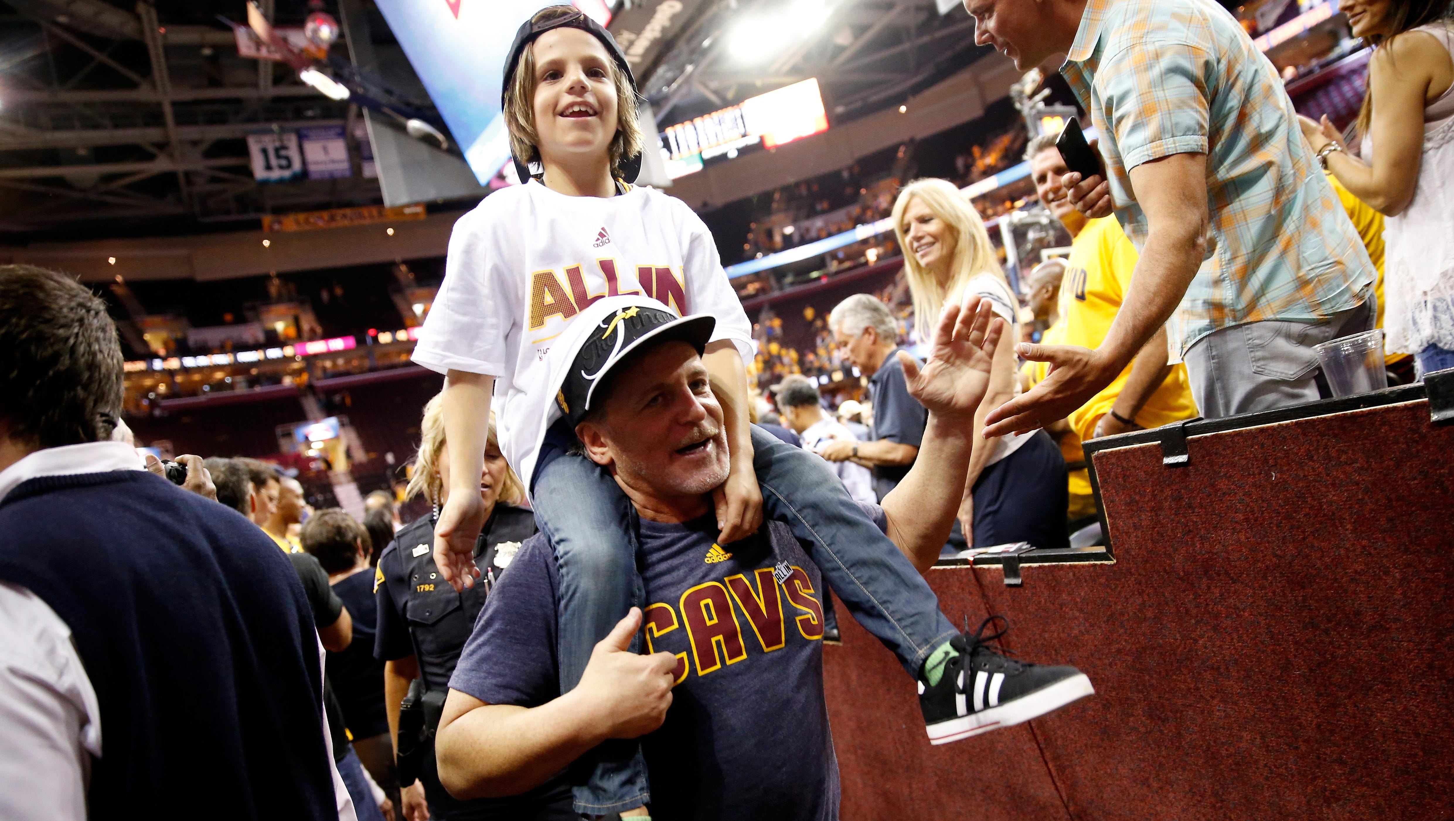 Cavaliers owner Dan Gilbert takes a youngster for a ride after winning the Eastern Conference.