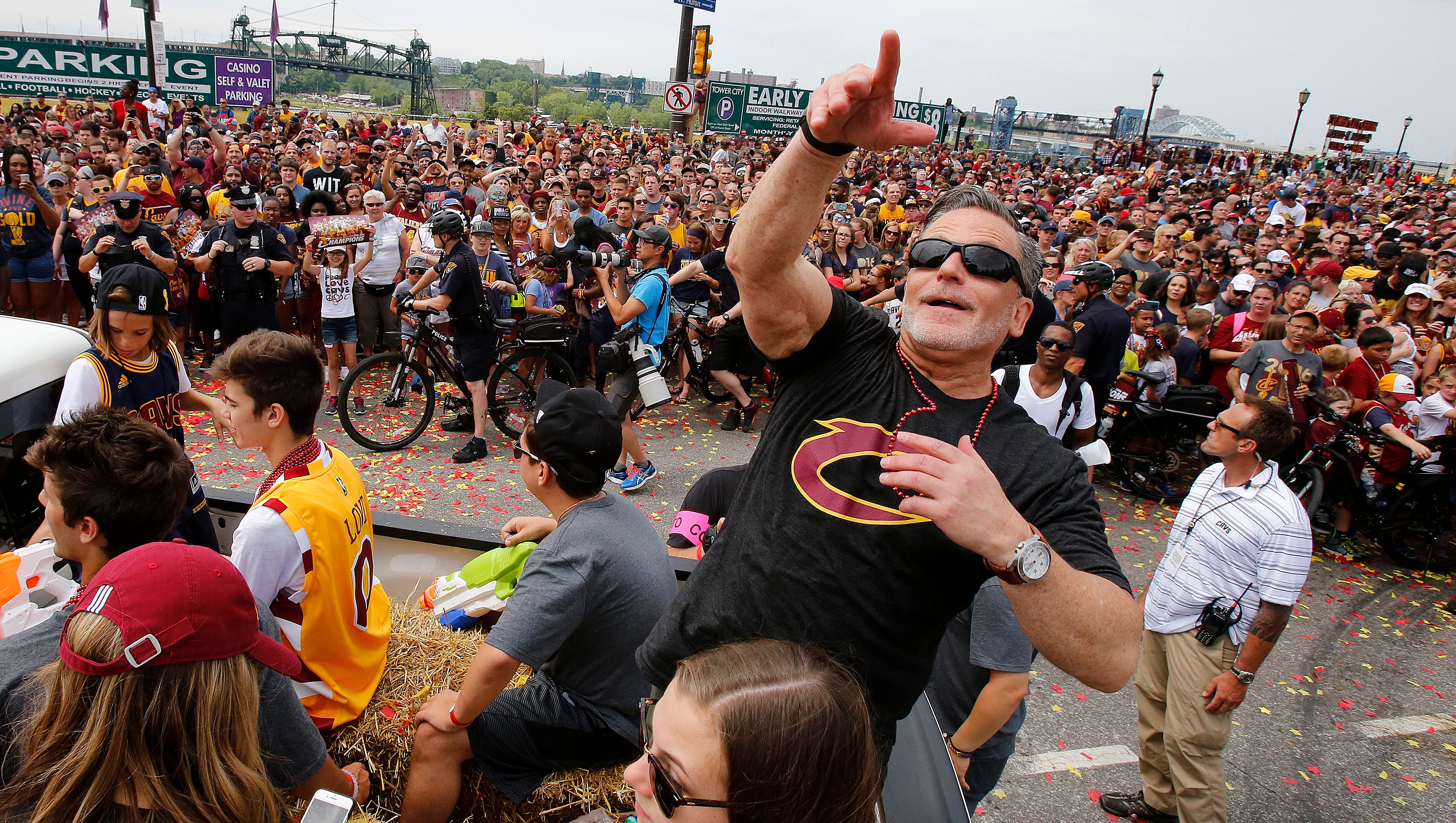 Cleveland Cavaliers owner Dan Gilbert tosses glass beads into the crowd during a parade celebrating the Cleveland Cavaliers' NBA Championship in downtown Cleveland Wednesday, June 22, 2016.