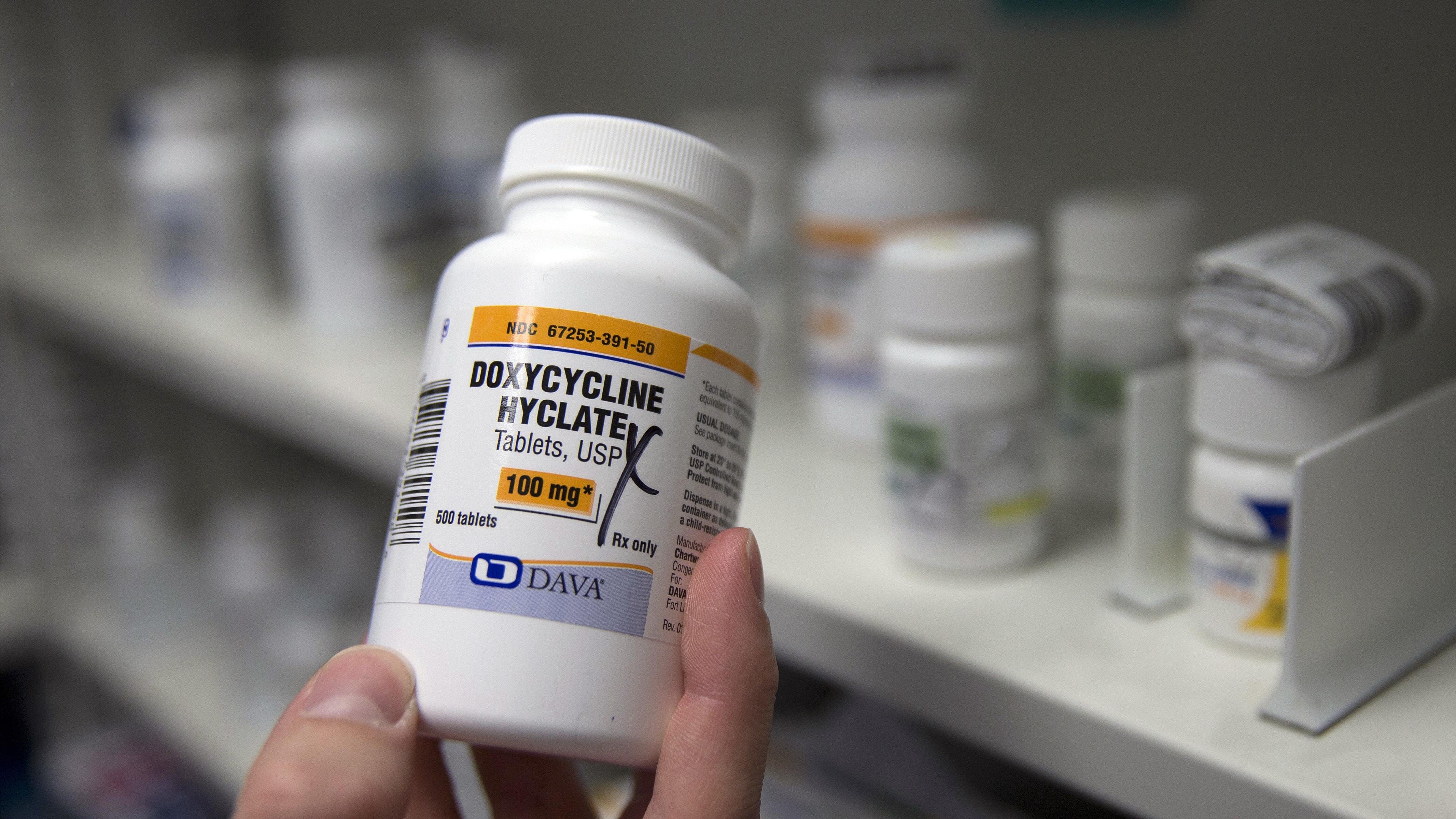 A pharmacist holds a bottle of the antibiotic doxycycline hyclate in Sacramento, Calif. According to a study released on Monday, kids who were seen via telemedicine visits were far more likely to be prescribed antibiotics than kids who went to a doctor’s office or clinic.