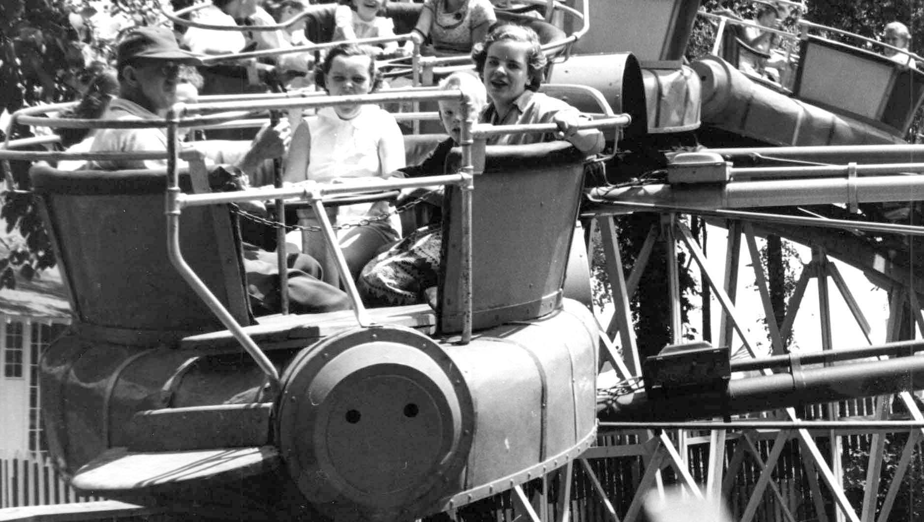 Day-trippers enjoy a spinning amusement park ride.
