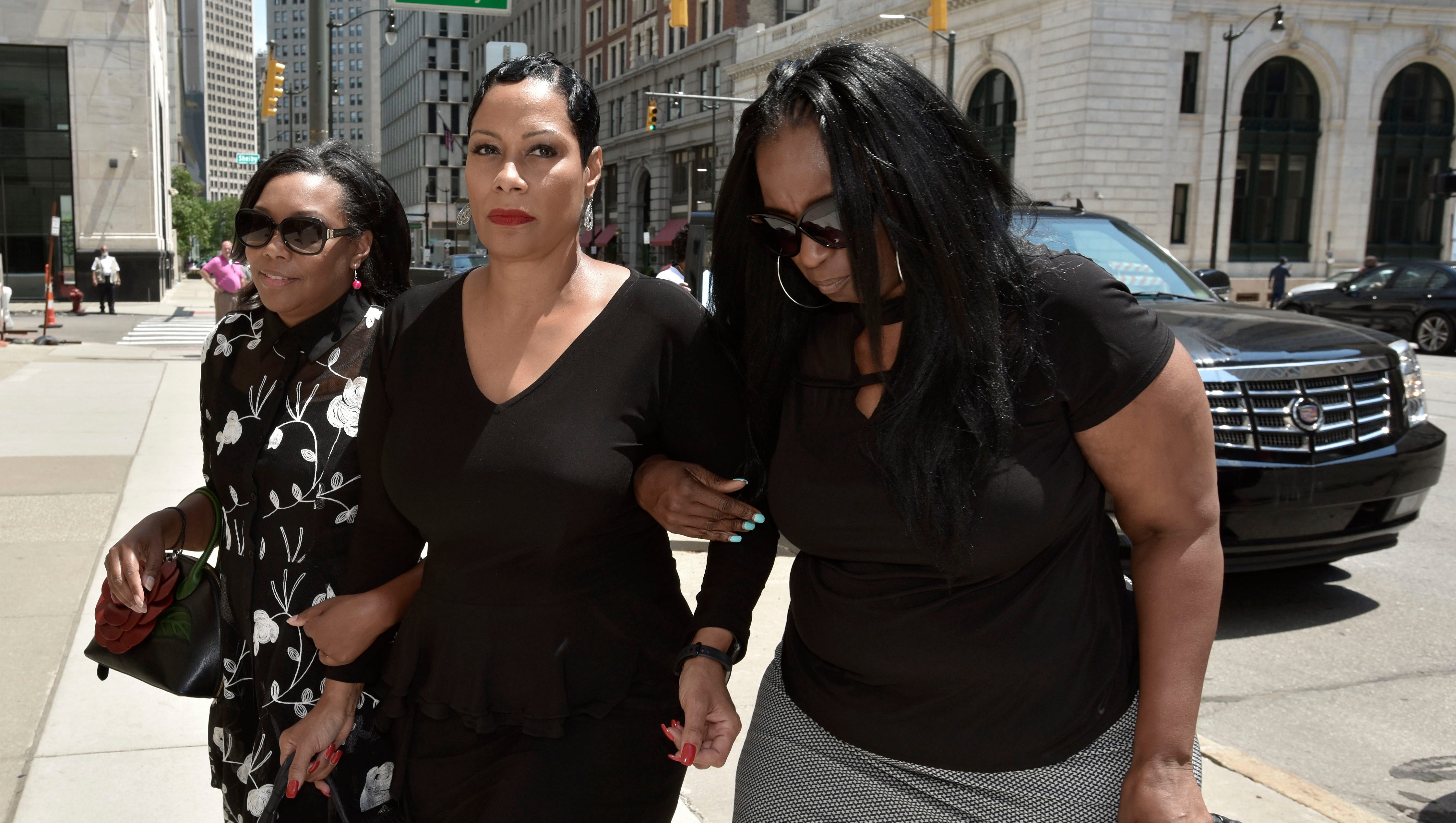 Monica Morgan-Holiefield, center, is escorted by two unidentified women as she enters the federal courthouse in downtown Detroit Friday  for her sentencing hearing.