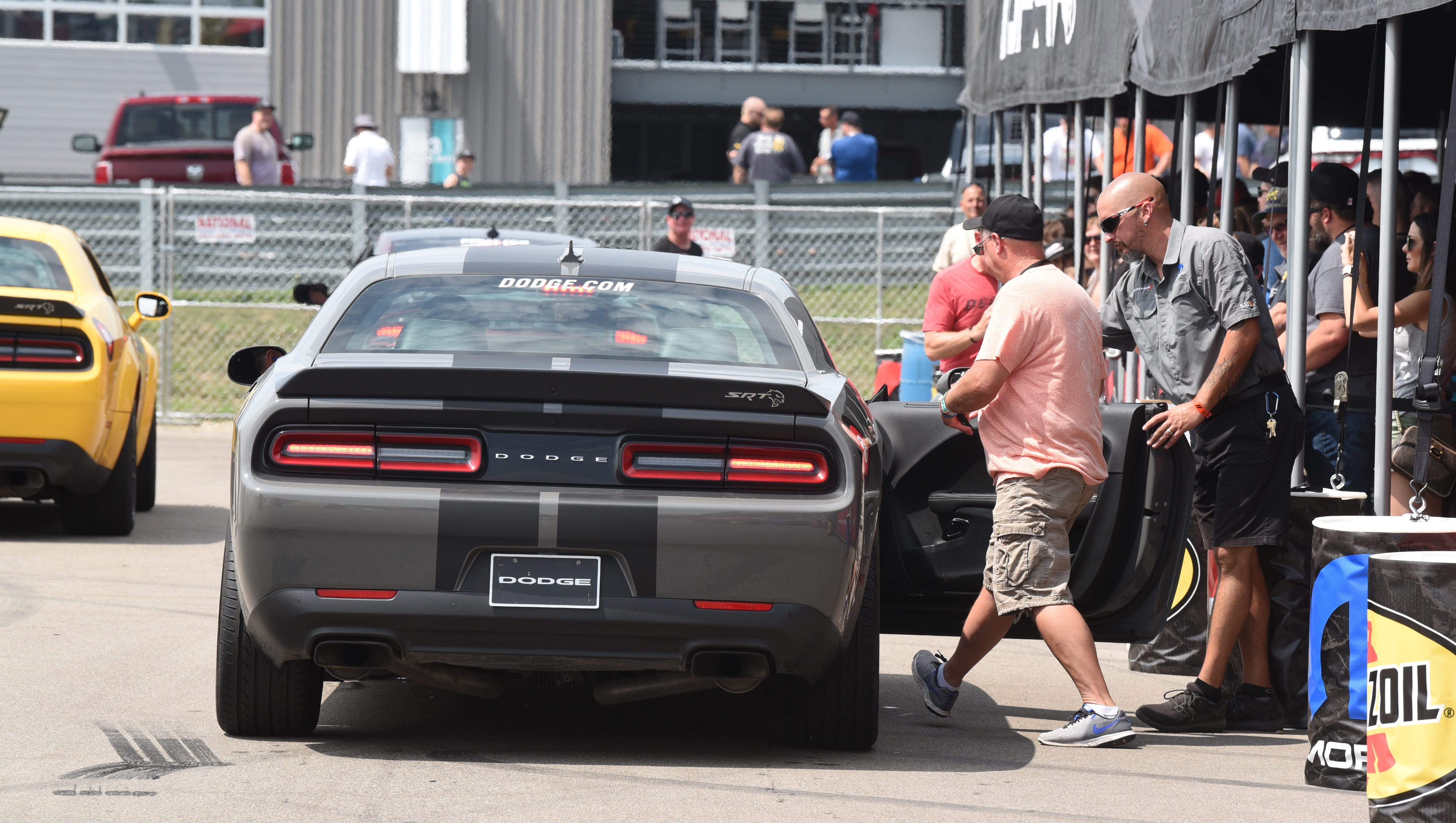 Fans leap aboard a Dodge Challenger Hellcat for a drift ride.