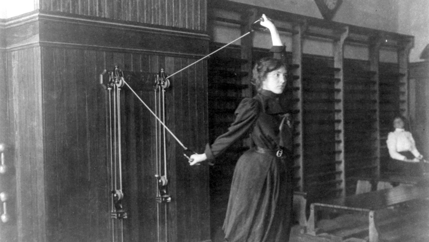 A high school girl exercises with pulleys in Washington D.C. in 1899.