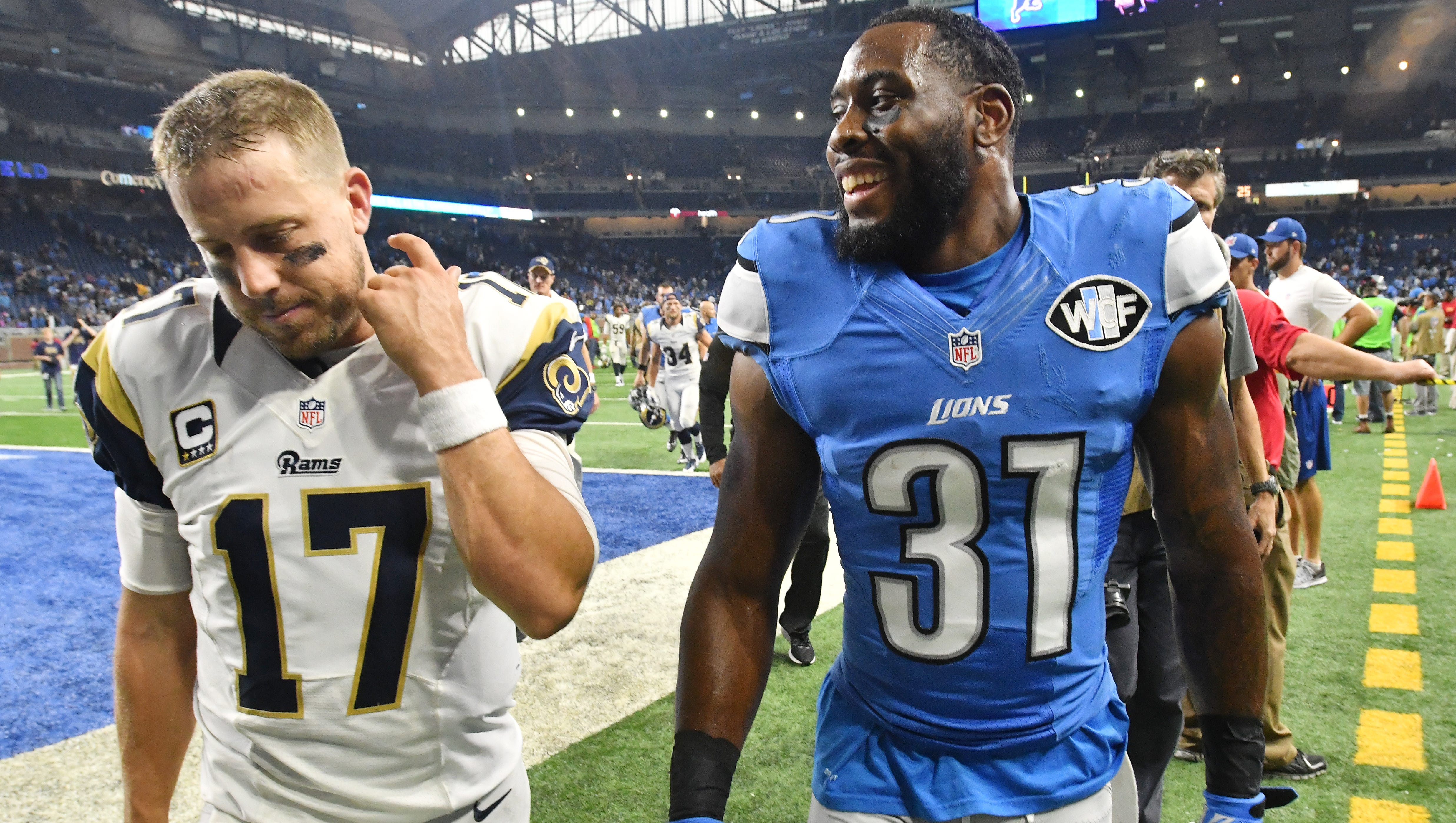 Rams quarterback Case Keenum and Lions safety Rafael Bush, who intercepted Keenum and allowed Detroit to run out the clock and win the game 31-28, walk off the field together.