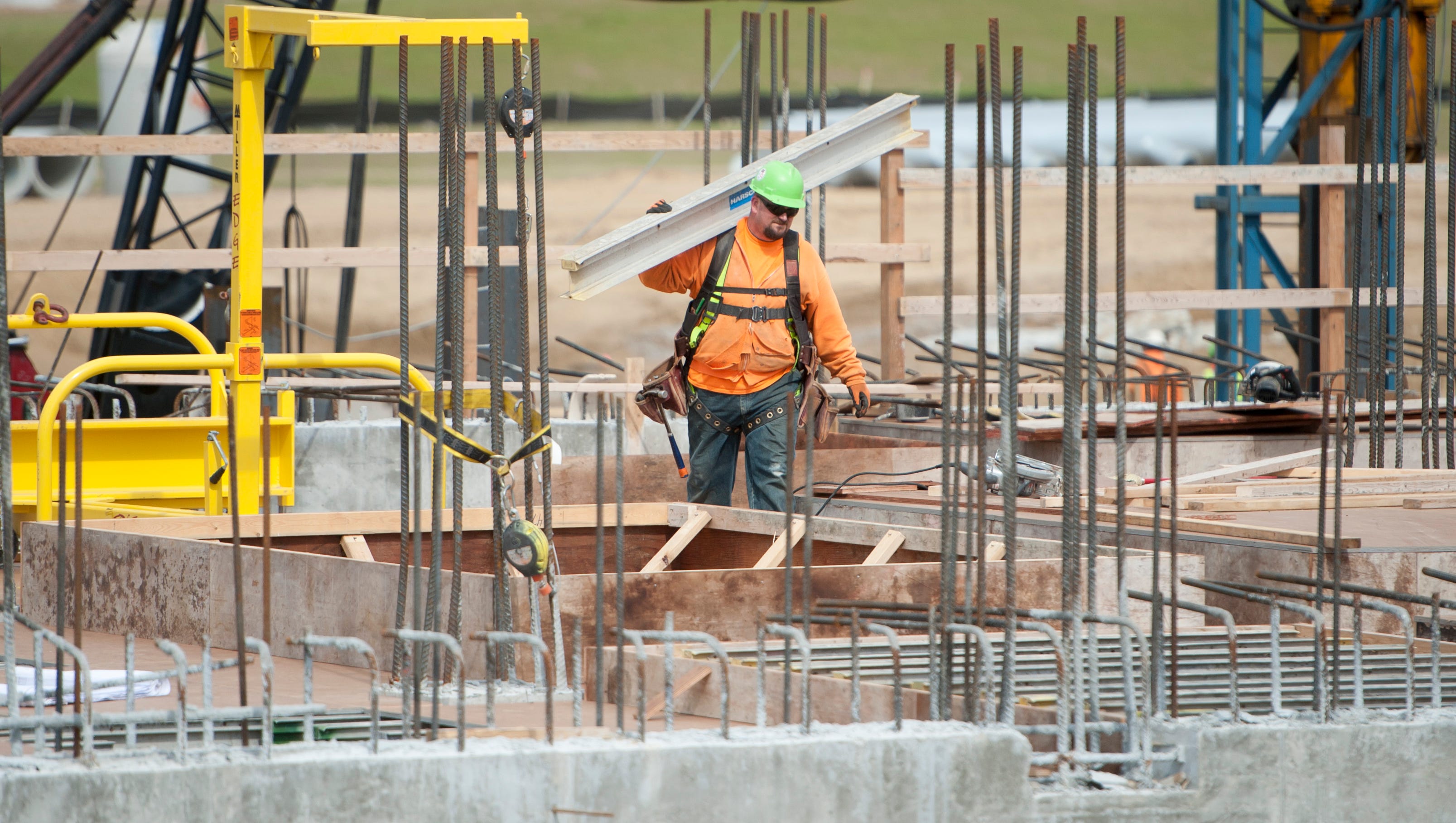A laborer carries a beam at the construction site of the new Karegnondi Water Authority  treatment plant.