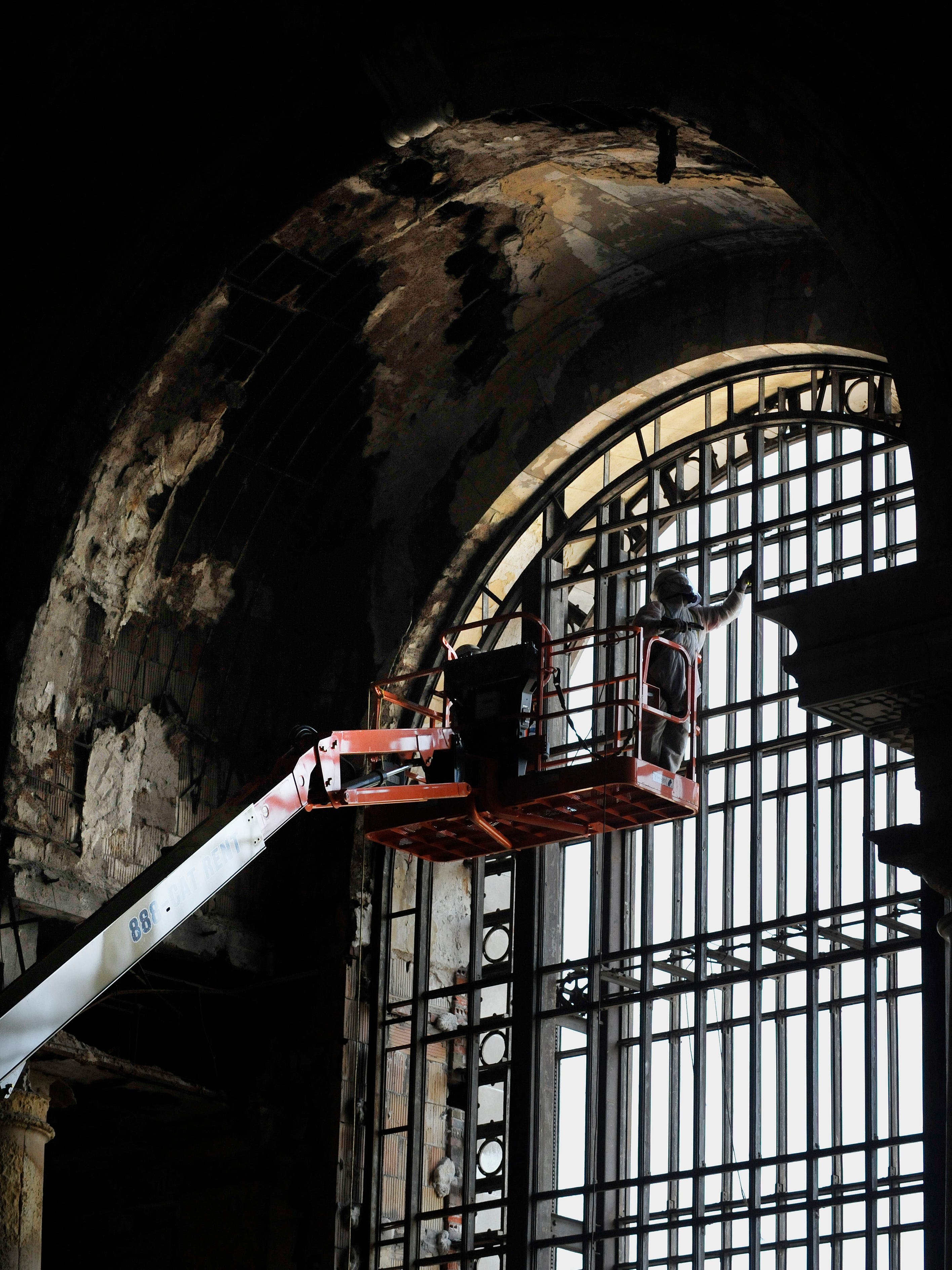 A worker prepares the metal framework for replacement windows inside the mezzanine of the train depot in 2011.