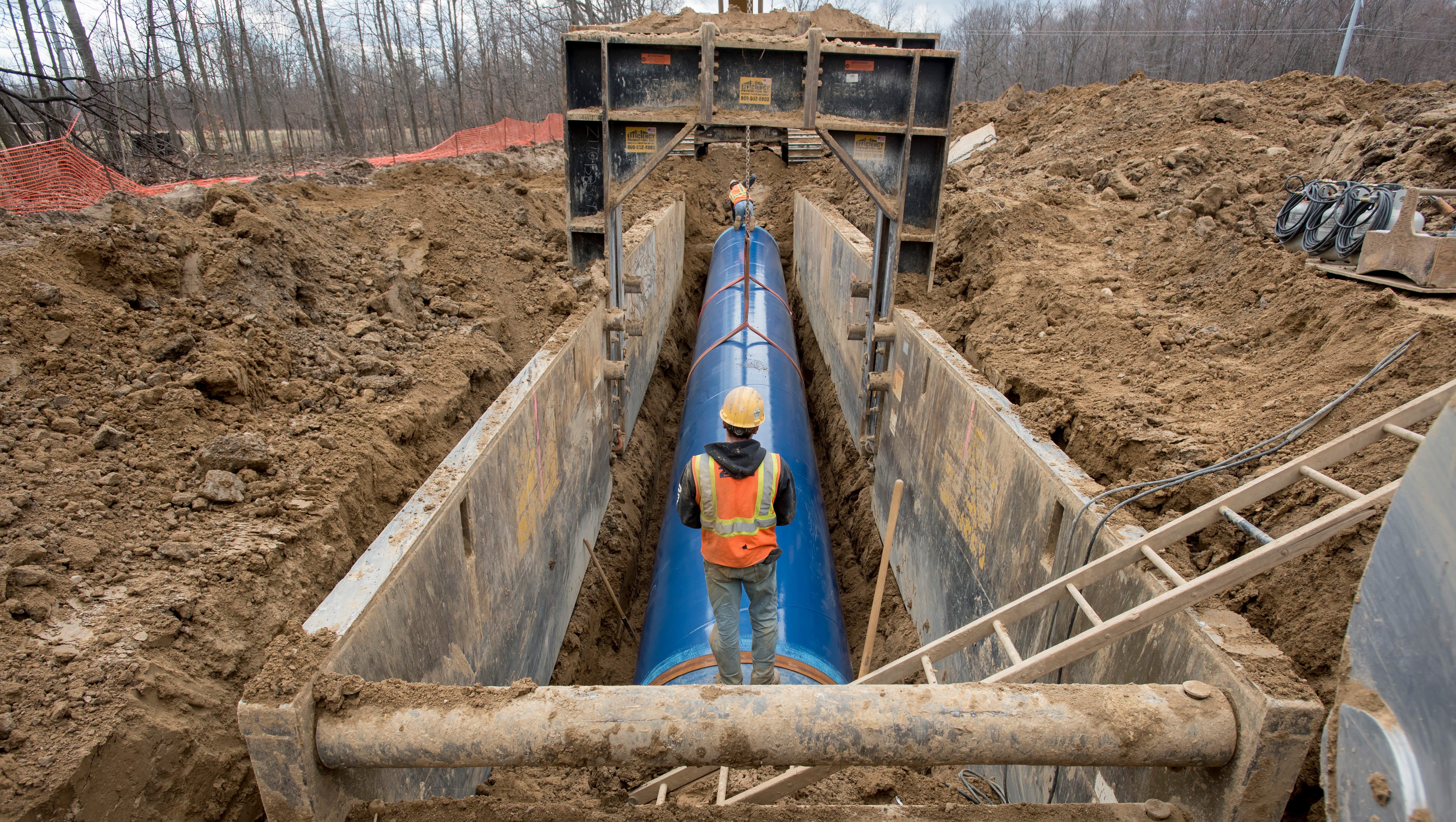 Laborers work on inserting a 50-foot section of the Karegnondi Water Authority pipeline near Oregon Township.
