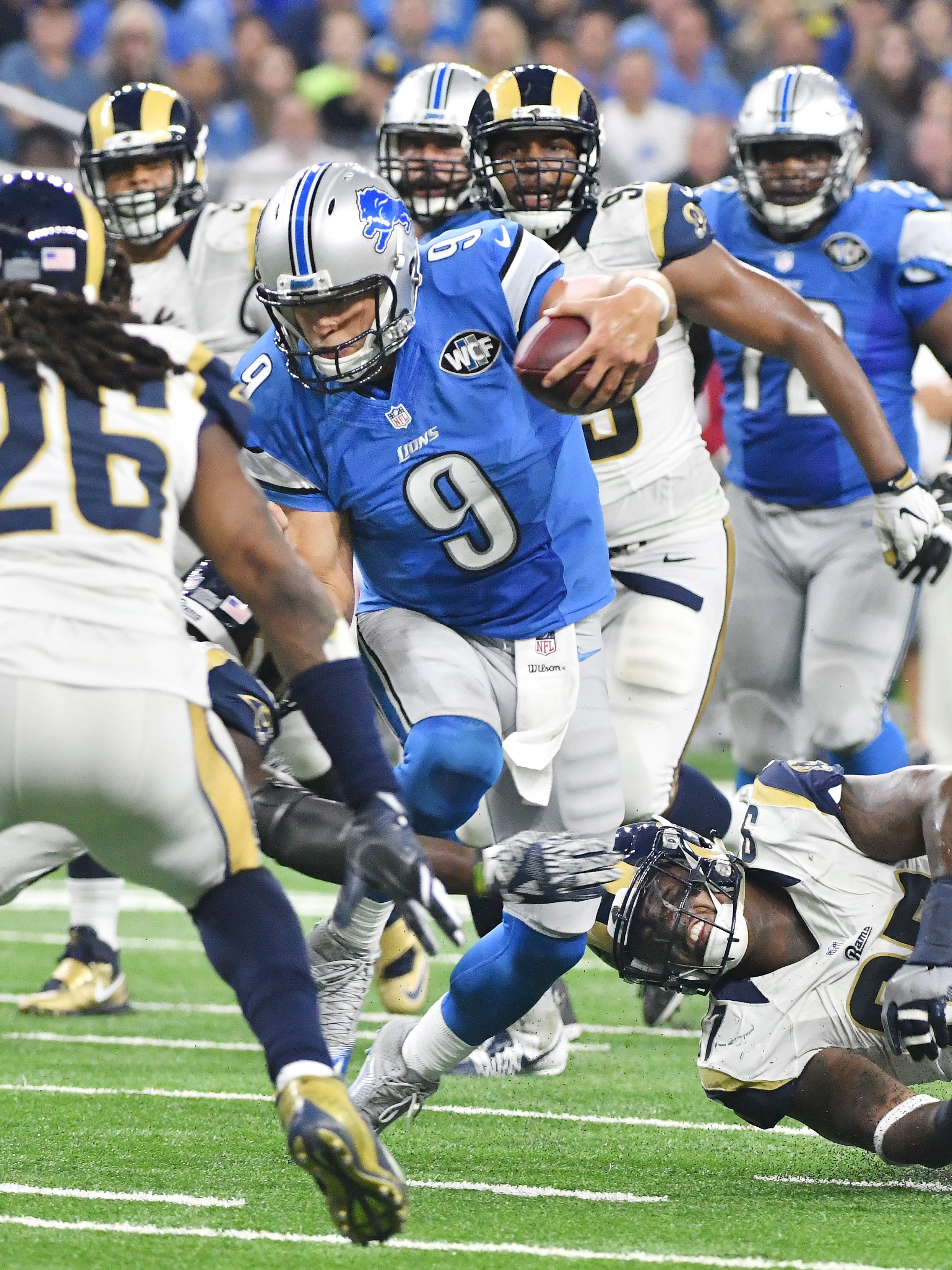 Lions quarterback Matthew Stafford doesn't slide but scrambles away from the Rams' Eugene Sims for a first down late in the fourth quarter Sunday in the Lions 31-28 win.