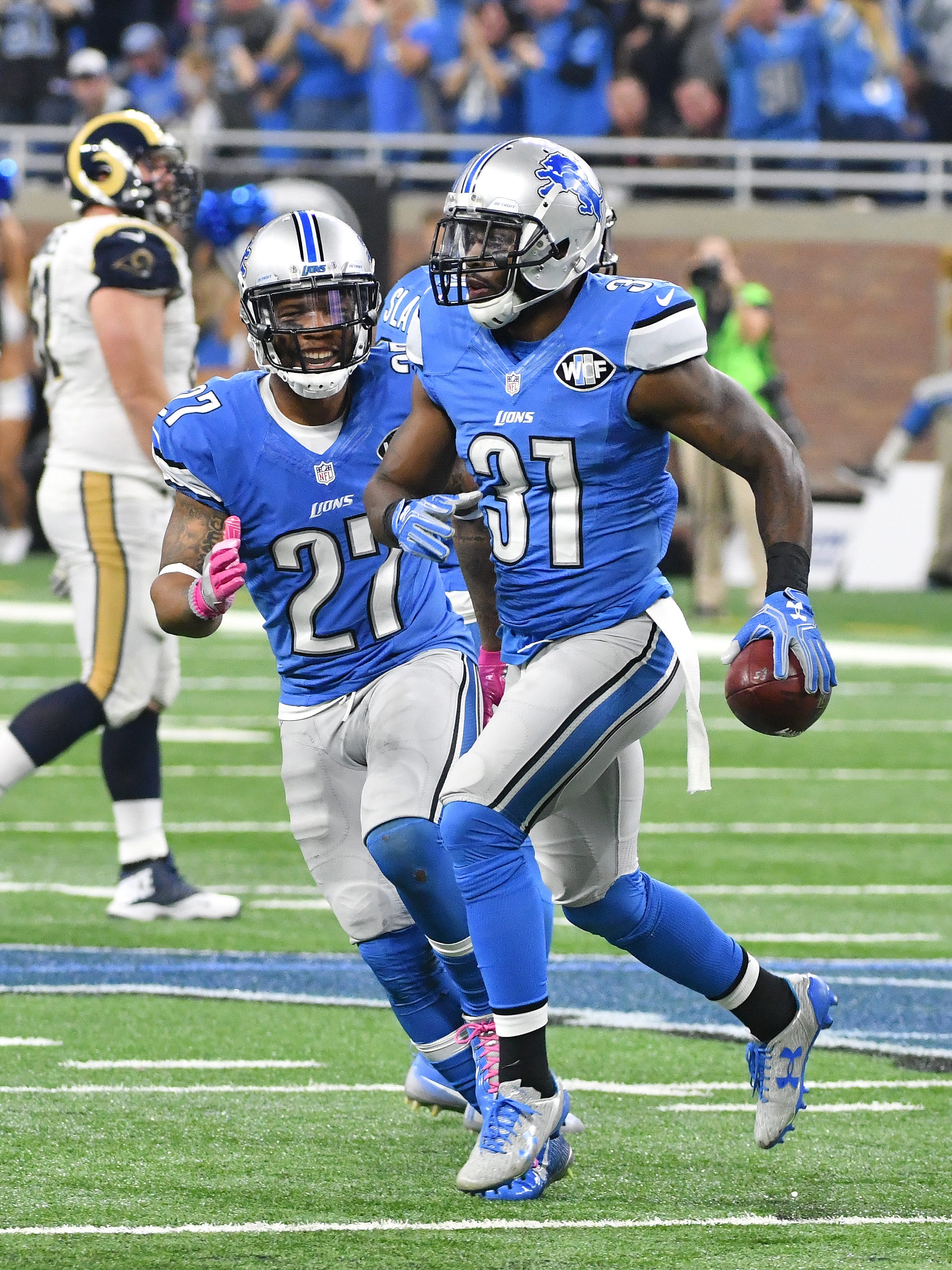 Lions safety Rafael Bush runs off the field with th ball after his late fourth quarter interception to seal Detroit's victory.