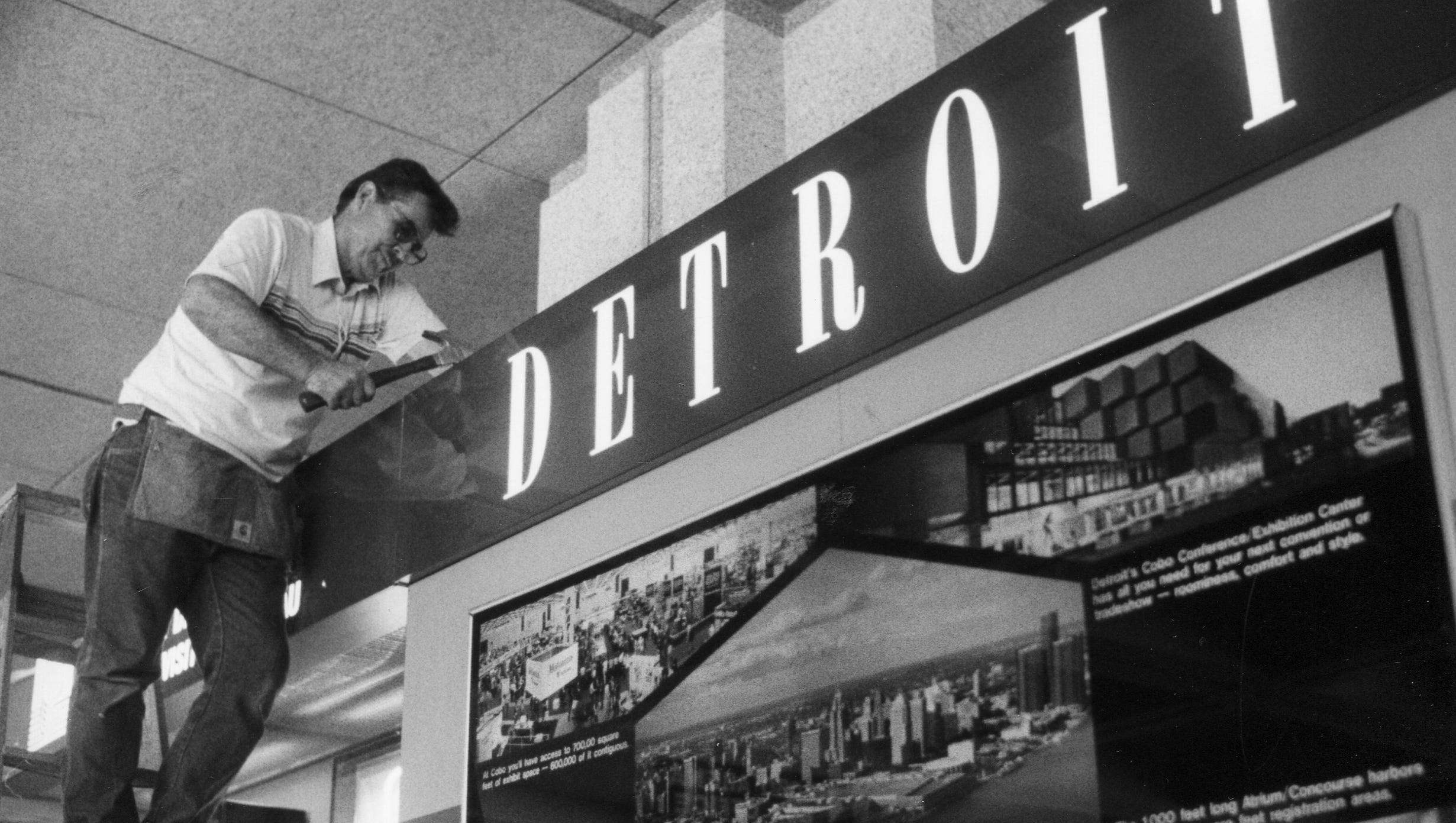 A worker puts finishing touches on a sign in Cobo on June 29, 1992.
