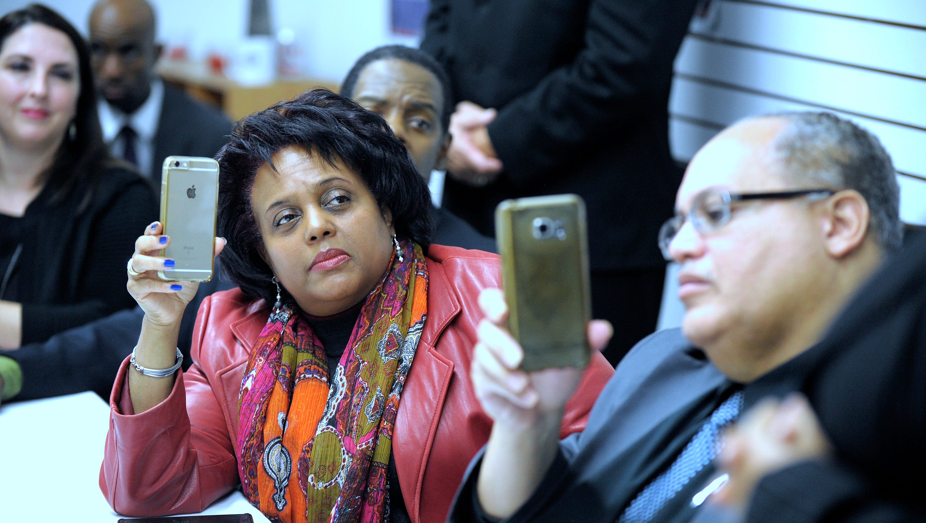 Denise Edwards, left, of Royal Oak, chief administrator for the Edwards Notebook Radio Commentary, and Apostle Keith Barr, right, of Auburn Hills, take pictures with their cellphones. Barr is pastor of the Family Worship Center in Rochester Hills.