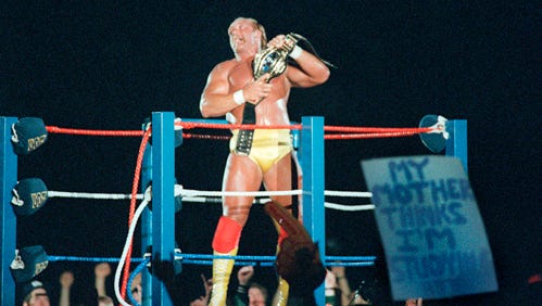 Hulk Hogan clutches his heavyweight championship belt as he takes a ride back to the locker room following his thrilling victory to close out WrestleMania III.