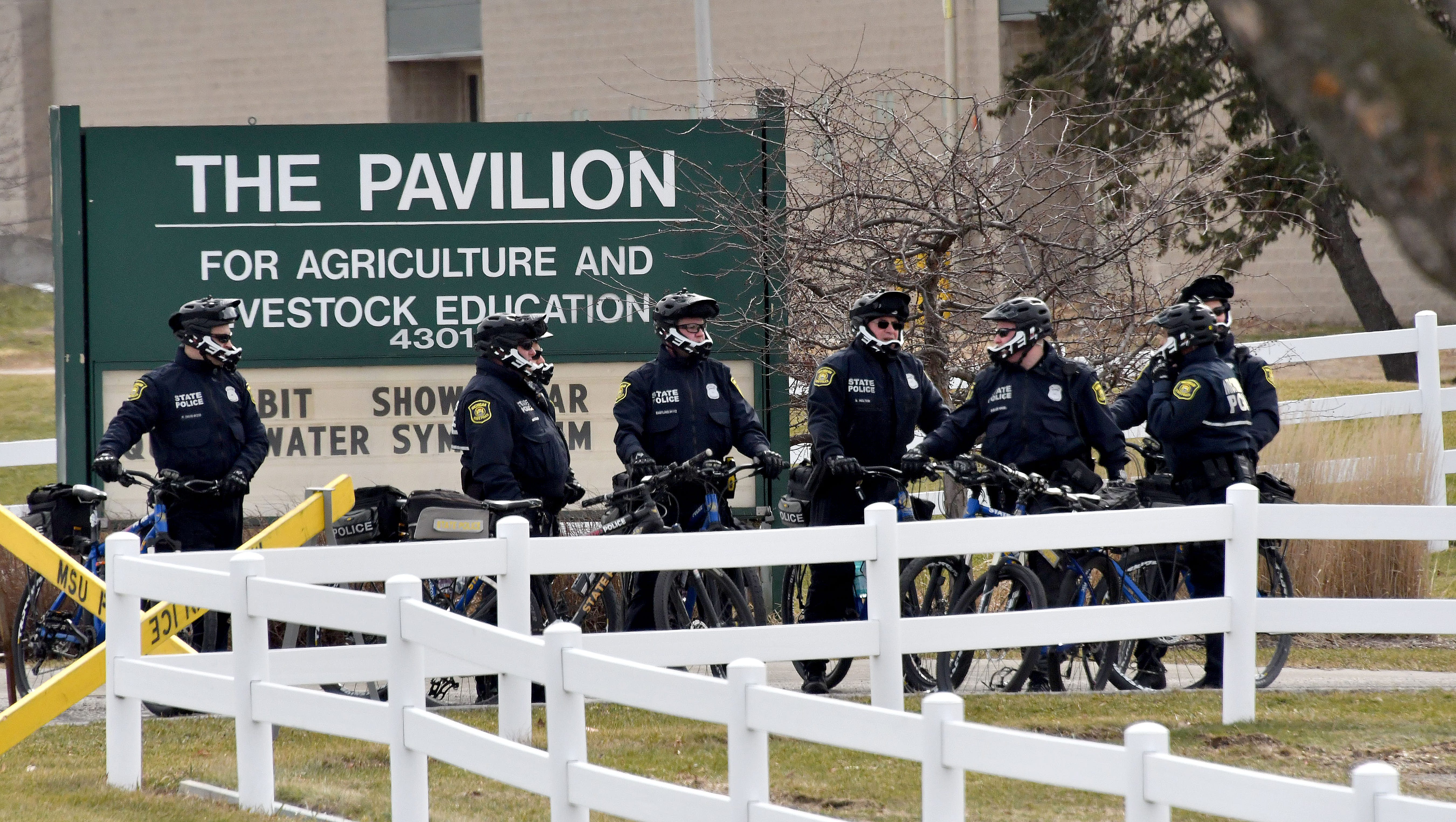 Michigan State Police officers on bicycles help separate protesters from the MSU Pavilion.
