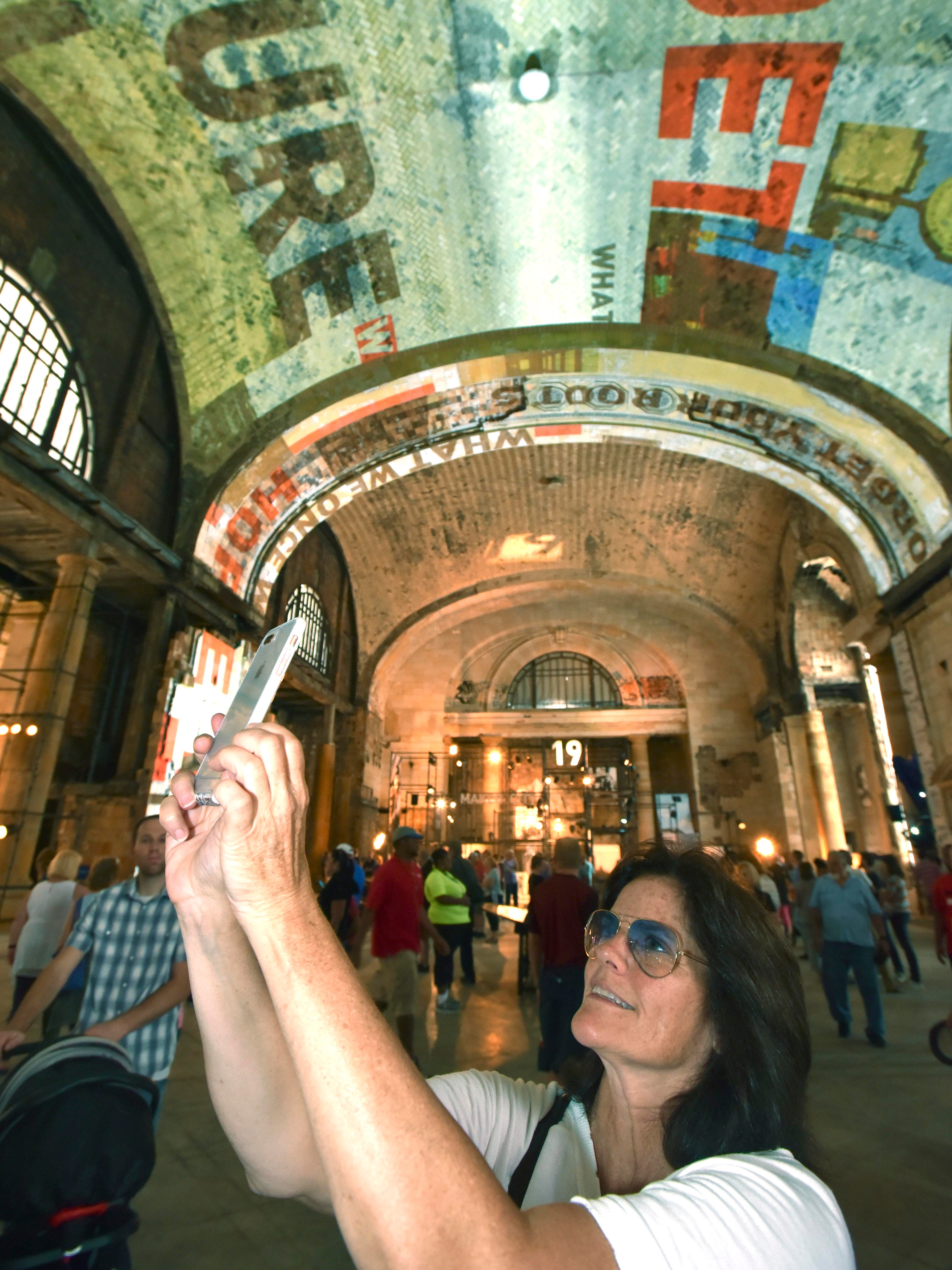 Jane Lehman, of Grosse Pointe, takes pictures of the ceiling in the lobby of the train station.