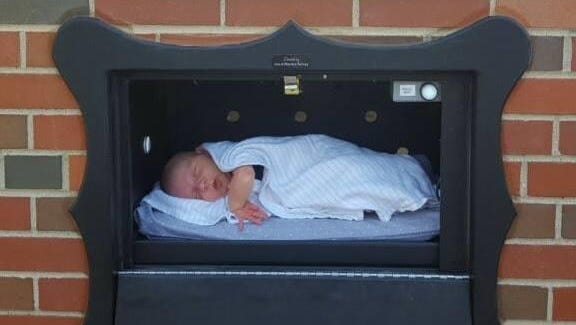 An infant rests inside a “baby box” installed in Indiana in a photo posted to the Safe Haven Baby Boxes Facebook page in November.