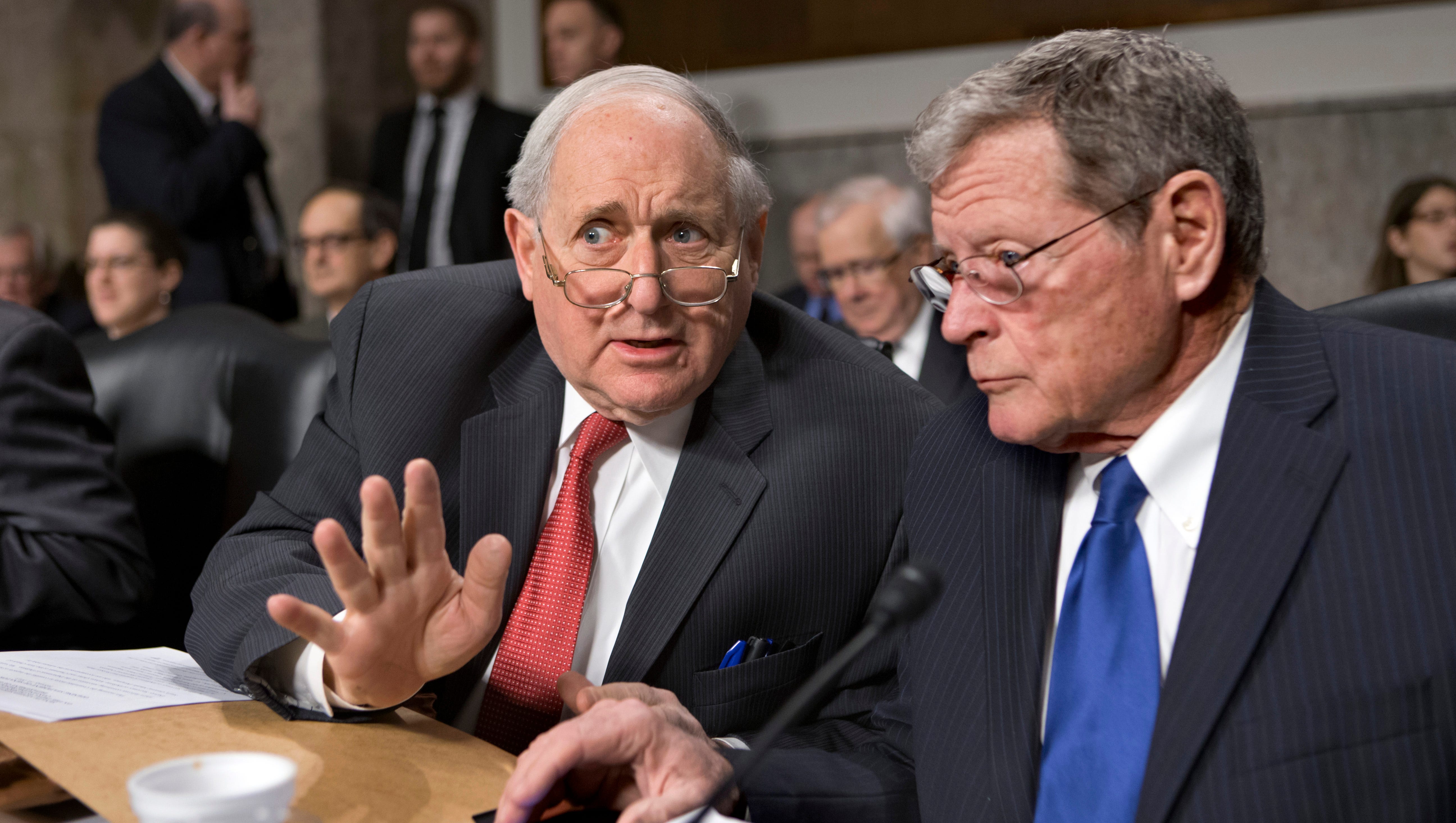 Sen. Carl Levin talks with  Sen. James Inhofe, R-Okla., on Capitol Hill Feb. 12, 2013, at the start of a hearing on the looming cuts to the defense budget.