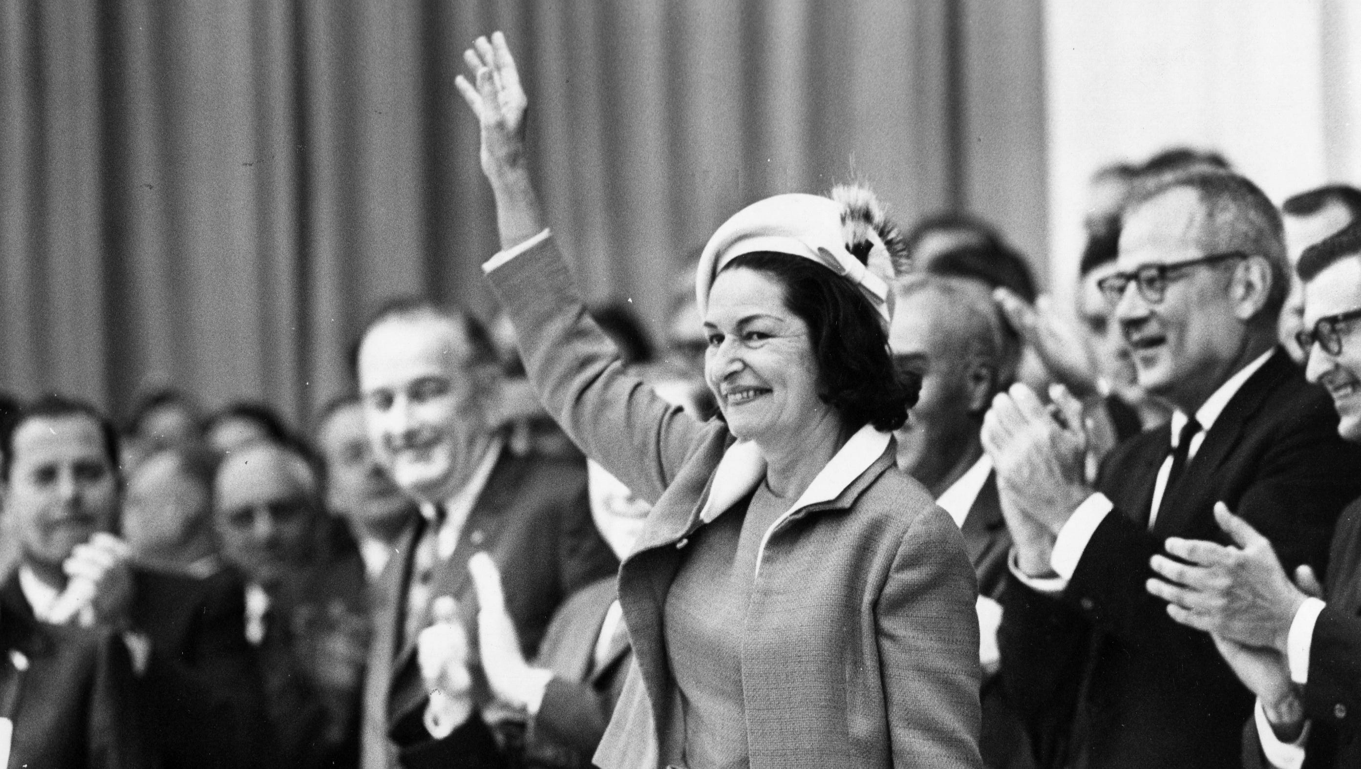 Lady Bird Johnson waves to fans with her husband, President Lyndon B. Johnson, left, at Cobo in 1966.