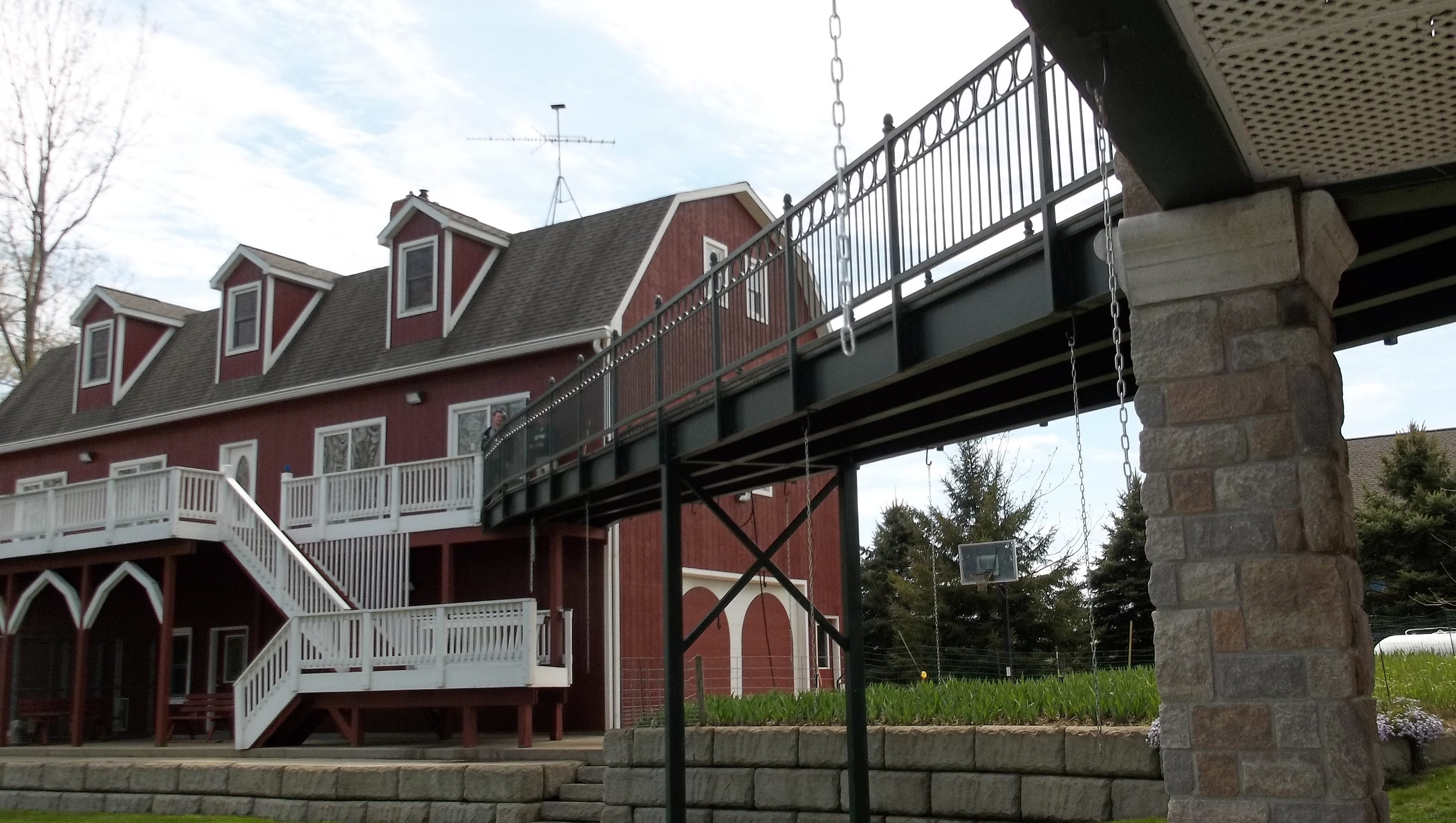 An elevated walkway connects an outbuilding to the main house.
