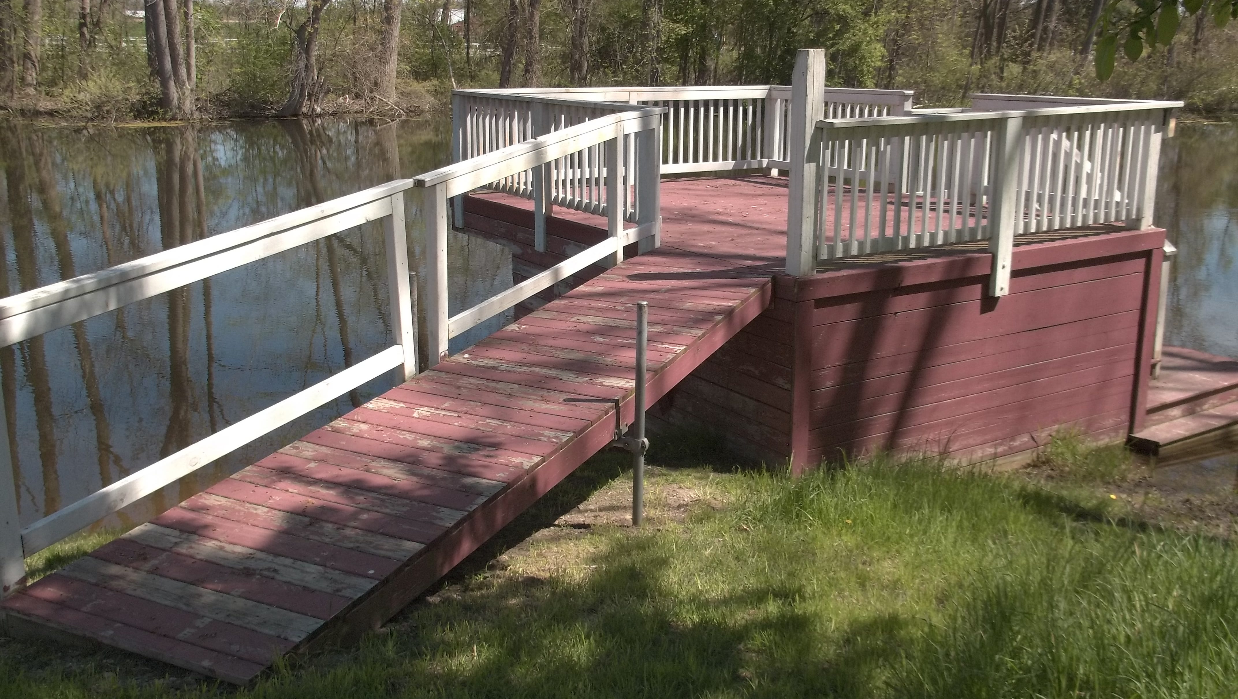 A ramp leads to a viewing platform beside the pond.