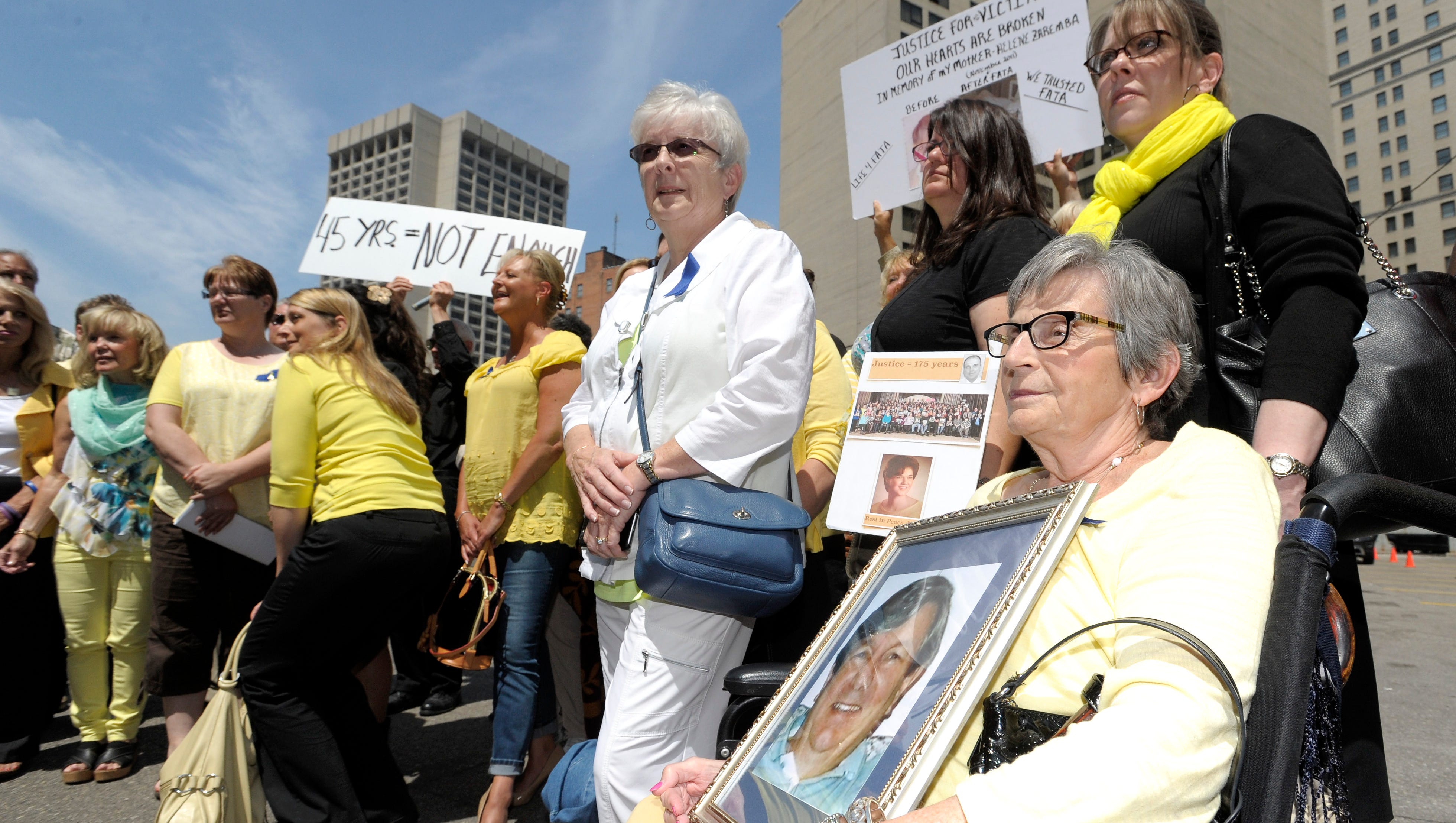 Pat Steinhelper, right, 77, of Waterford, holds a picture of her husband, Jerry Steinhelper, who died due to complications of chemotherapy at the hands of Dr. Fata. She poses for a group shot with other victims and victims' family members after the sentencing.