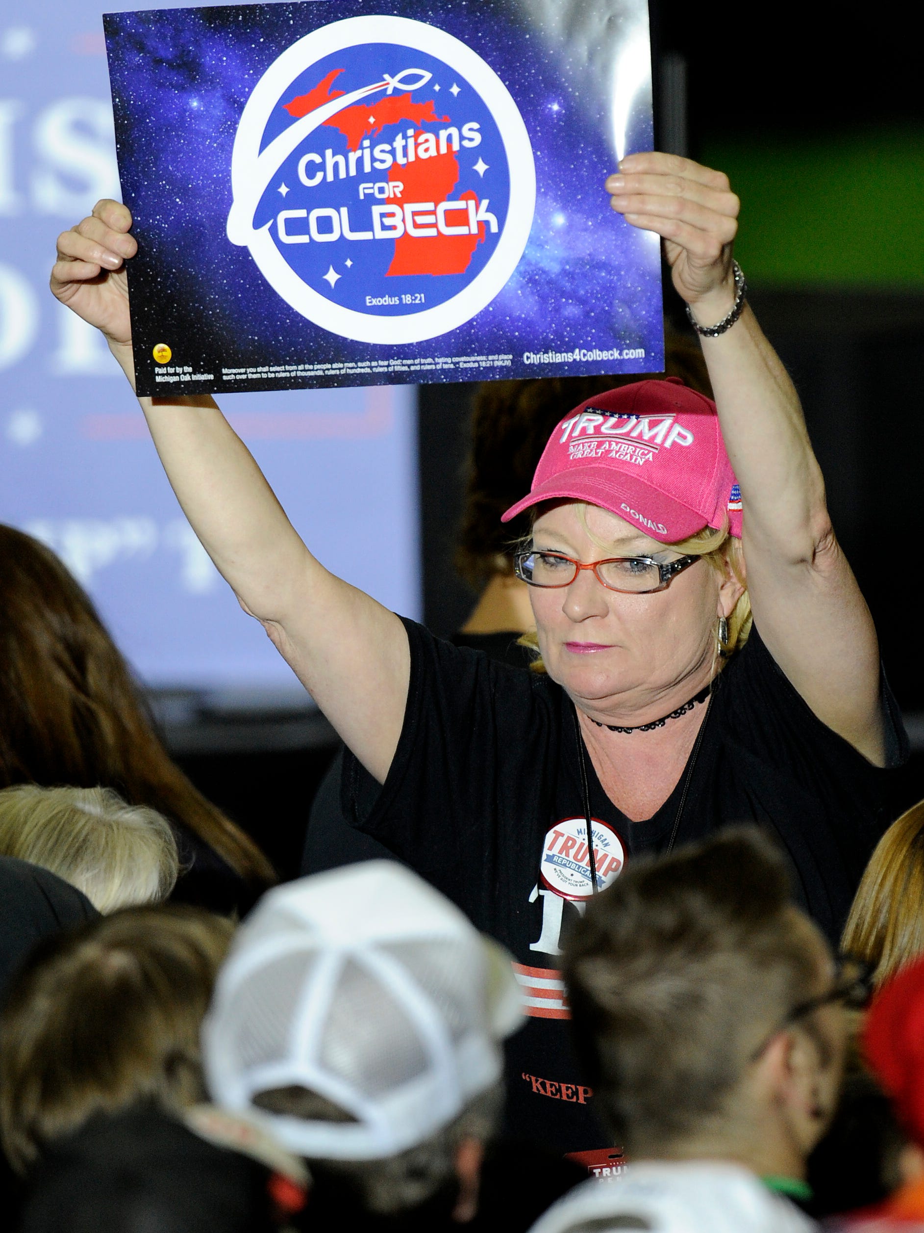 A woman holds up a Christians for Colbeck sign. Patrick Colbeck is on the Republican primary ballot for governor.