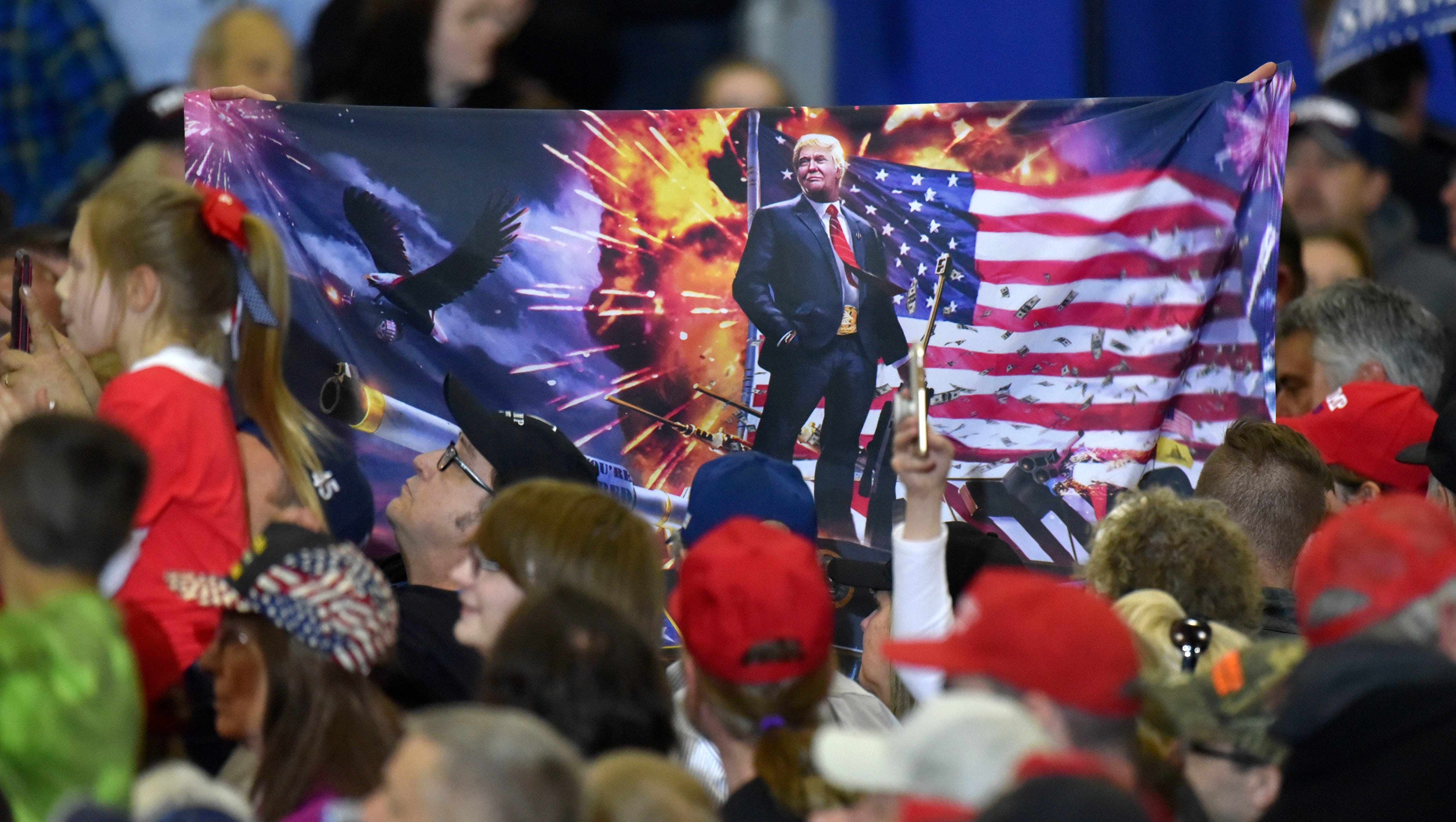 A supporter holds up a Trump flag.