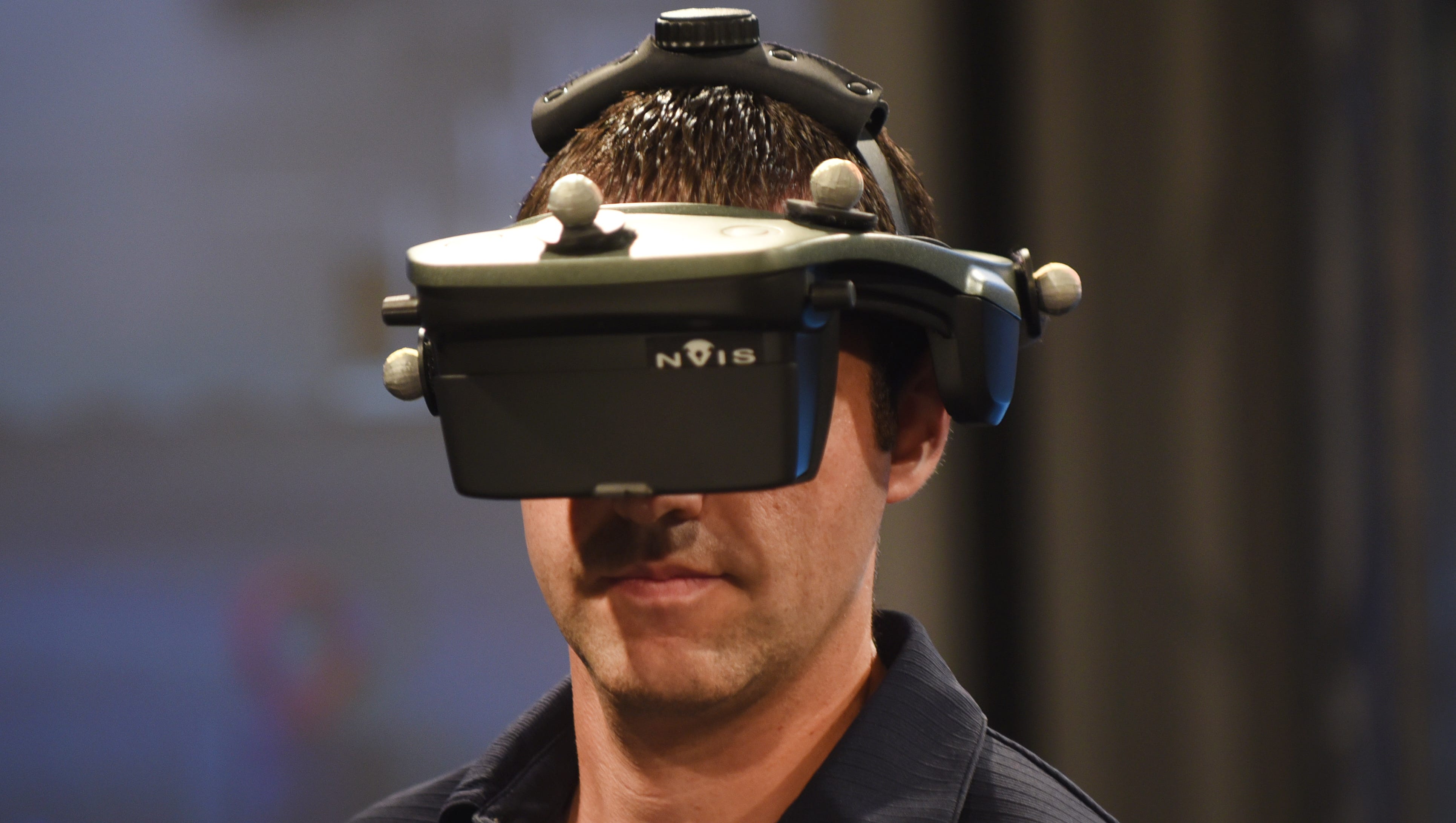 Ergonomist Rob McLean wears immersive virtual reality headgear as he demonstrates the marriage of a transmission to engine as part of Ford Motor Co.'s Virtual Manufacturing Technology.