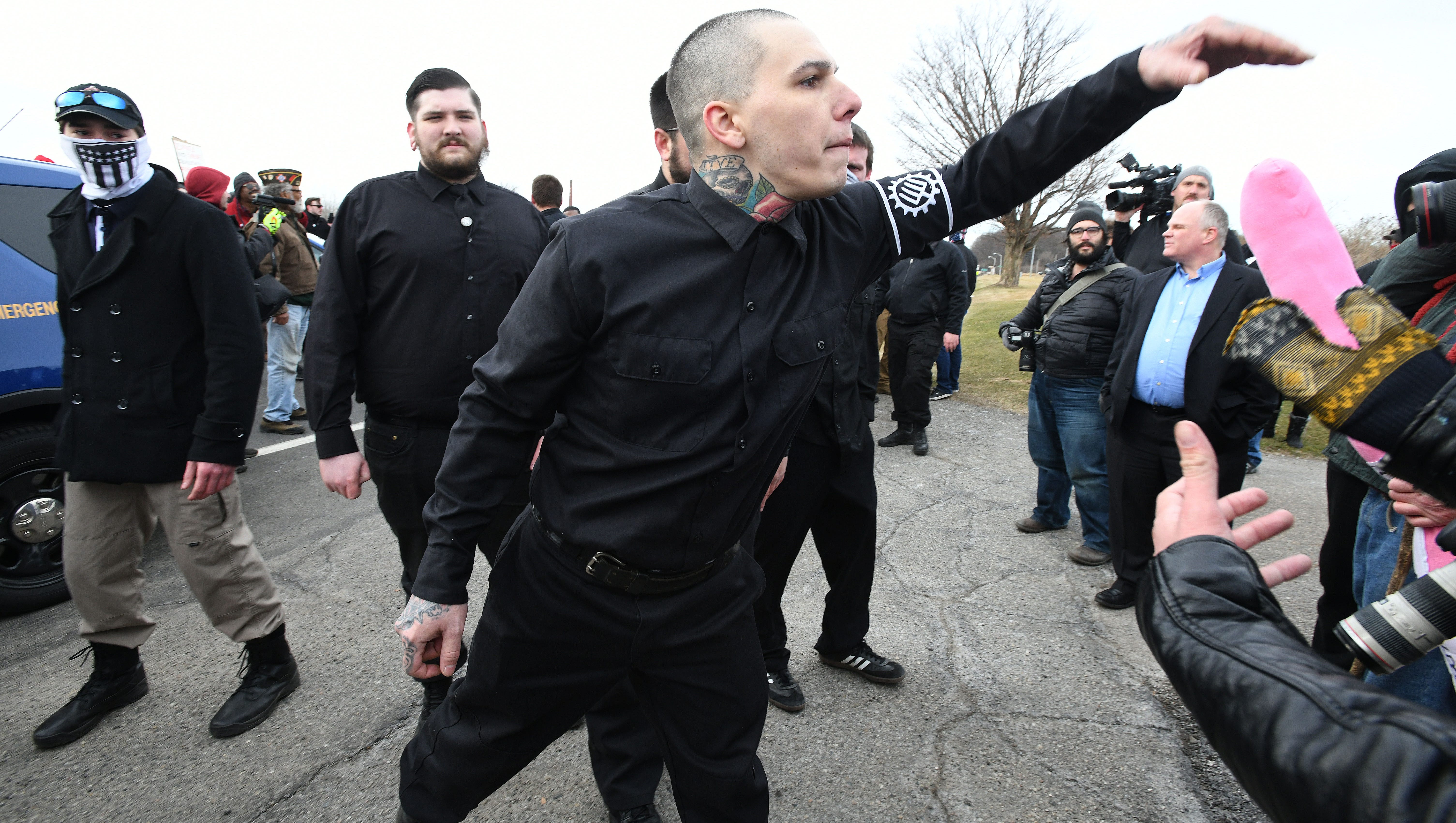 A pro-Spencer member of the white-supremacist TWP, wearing the four pronged pitchfork on his armband, clashes with protesters outside the Richard Spencer speech.