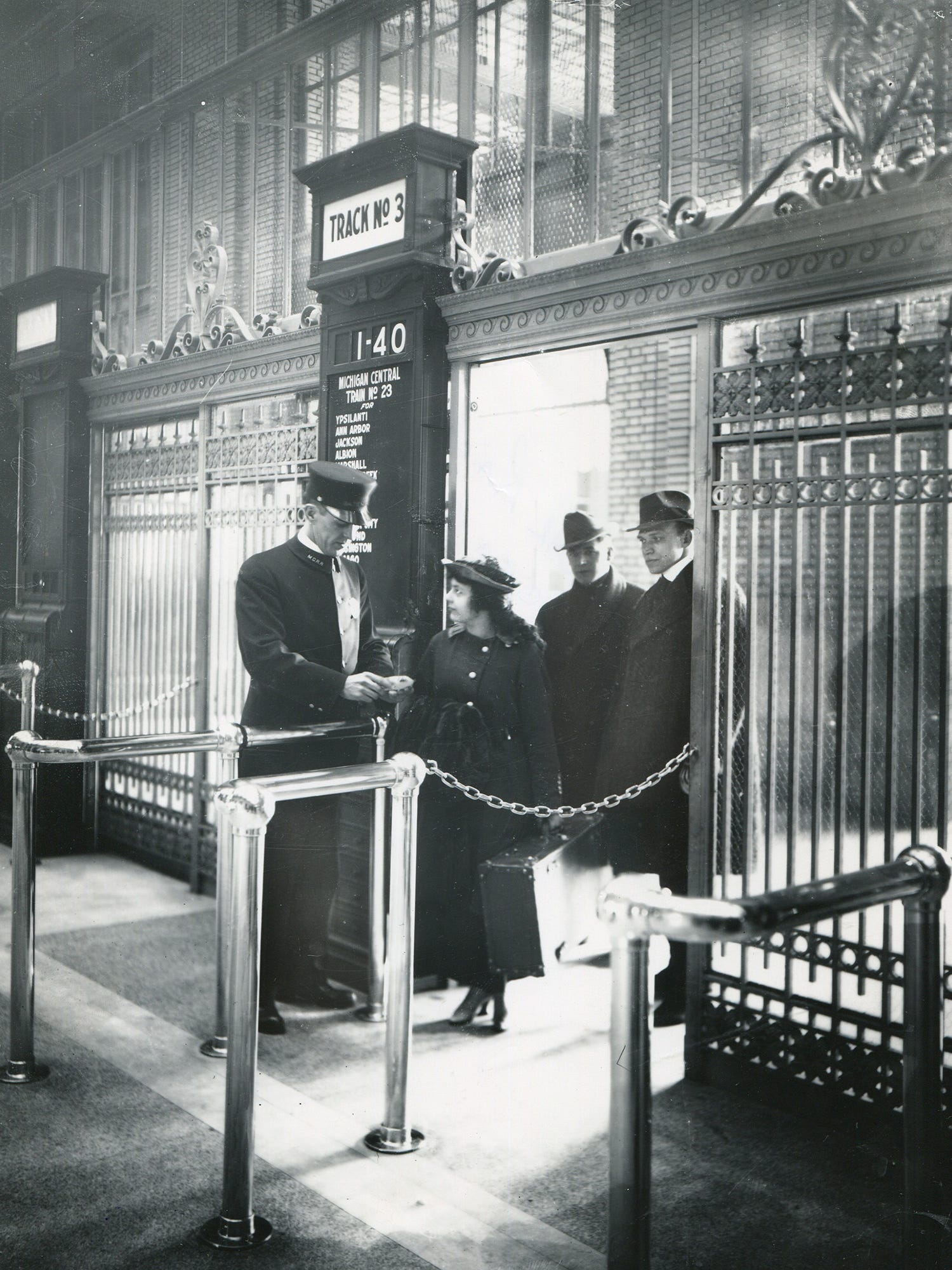 A stationmaster checks a passenger's ticket at Michigan Central Depot in an undated photo.