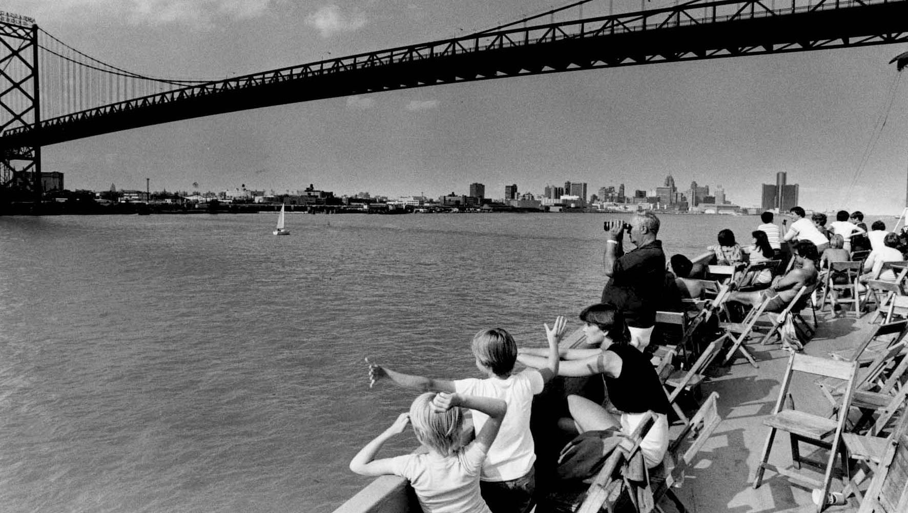 Passengers enjoy the view from a Boblo boat as it passes beneath the Ambassador Bridge.
