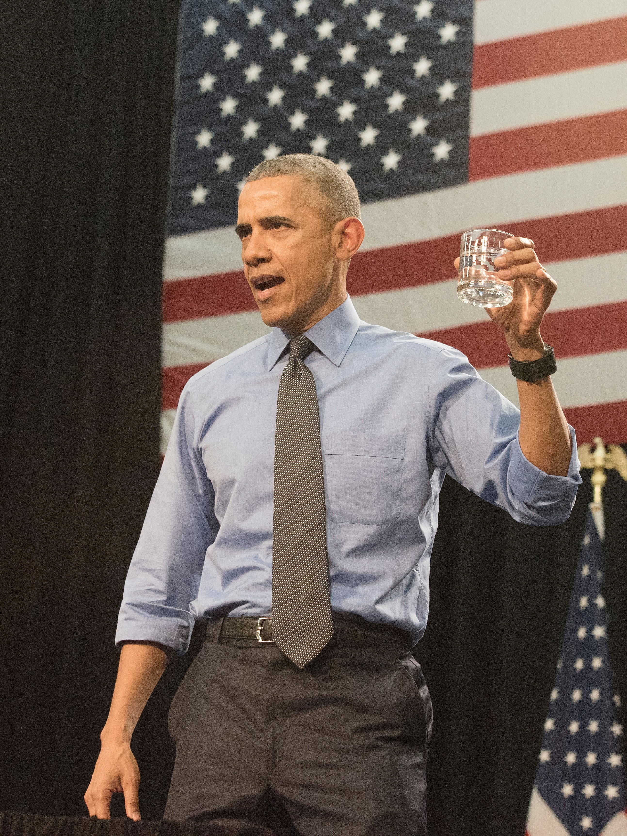 President Barack Obama holds a glass of filtered Flint water as he speaks at Northwestern High School in Flint on May 4, 2016.