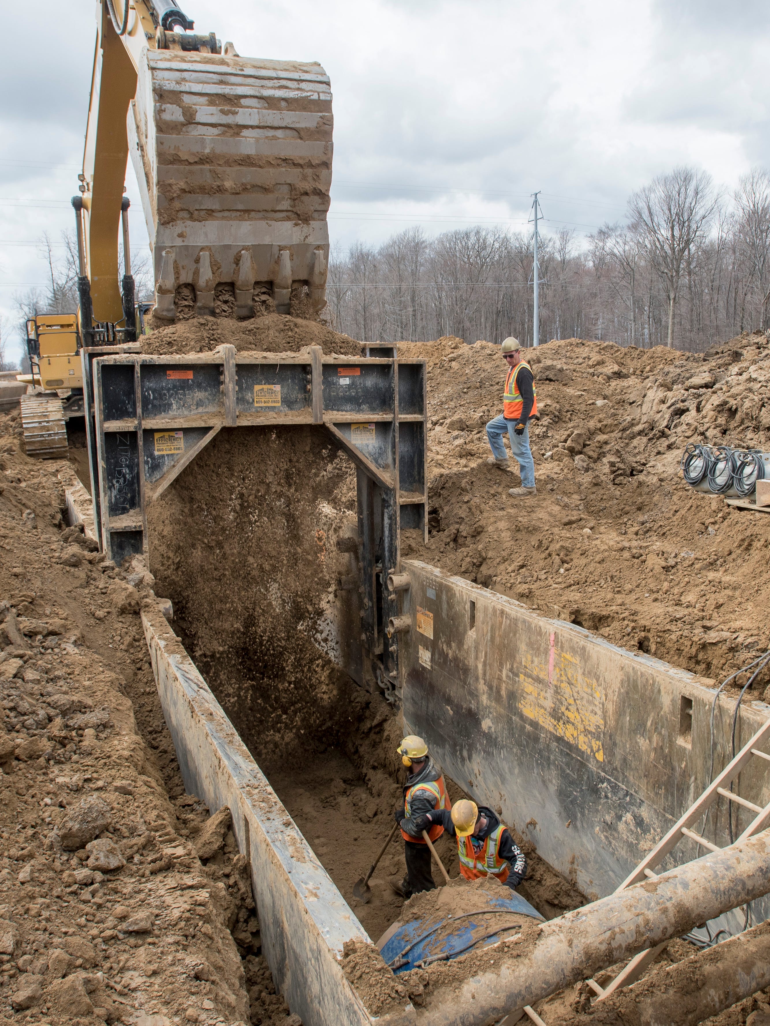 Laborers work in a ditch preparing the ground for a section of the Karegnondi Water Authority pipeline near Oregon Township.