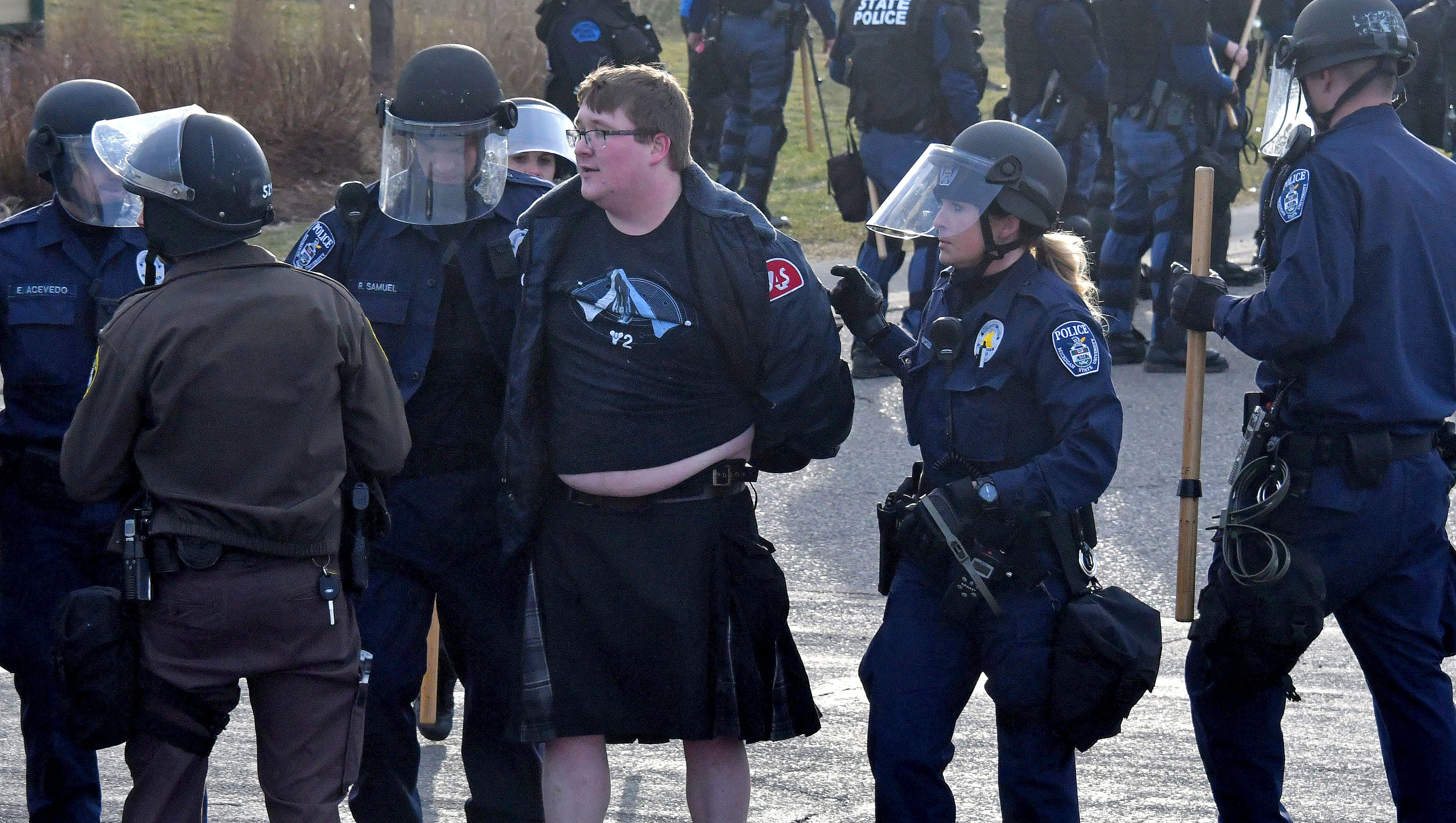 An anti-Spencer protester in a kilt is arrested and loaded into a police van.