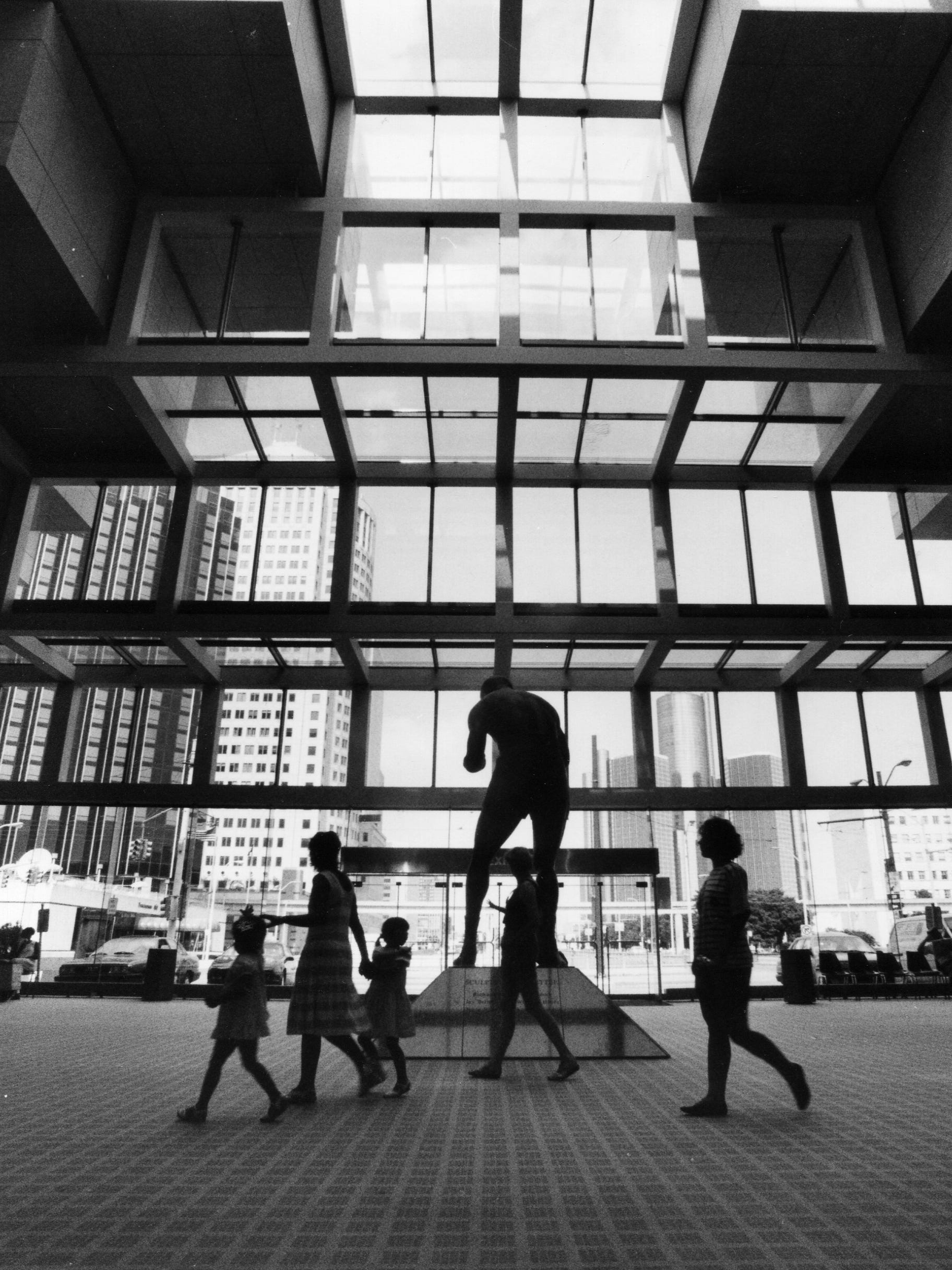 People walk past the statue of Joe Louis near the entrance to Cobo Center on Aug. 24, 1990. The center was expanded in the 1980s.