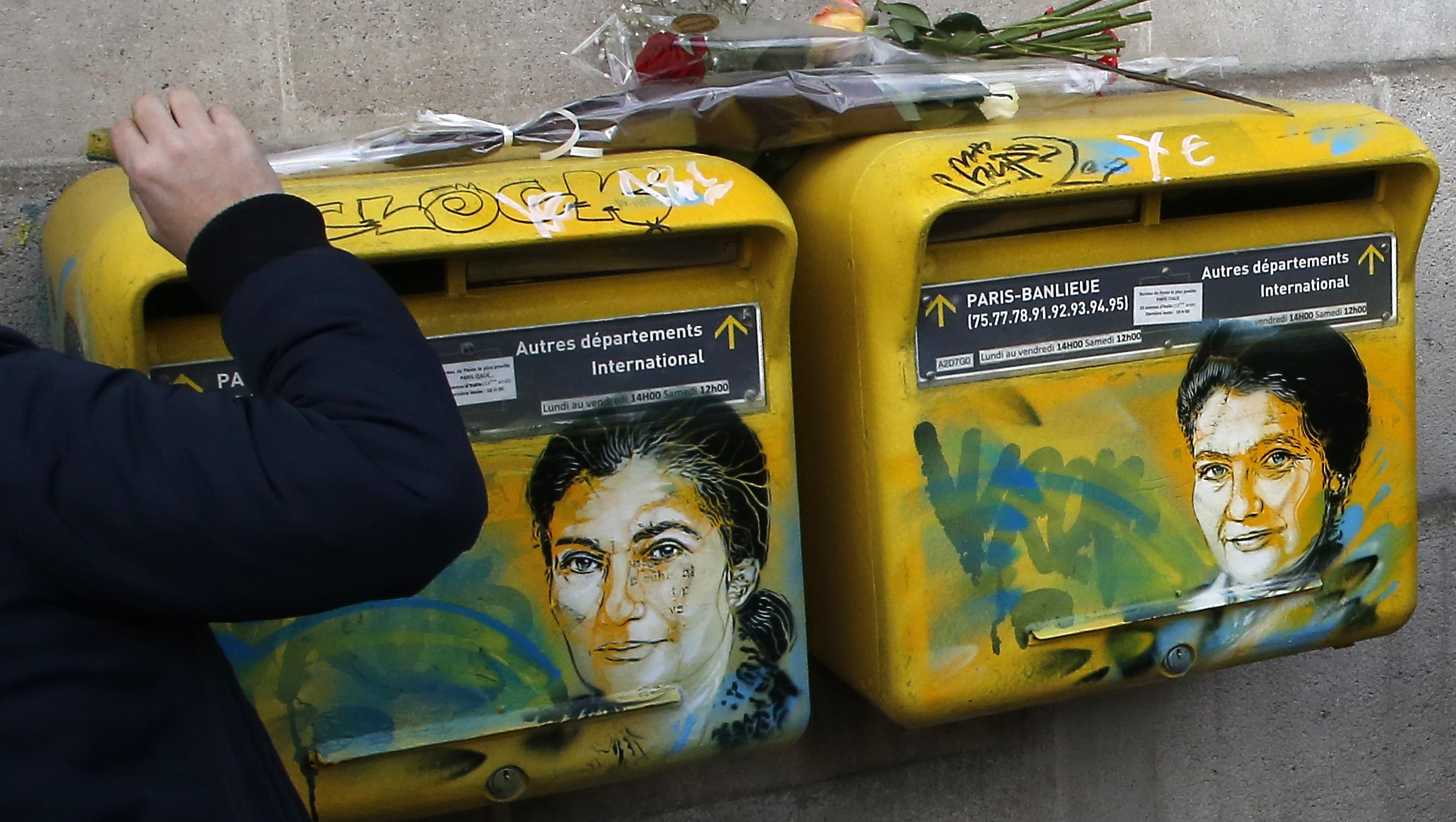 French street artist Christian Guemy, known as C215, cleans the vandalized mailboxes with swastikas covering the face of the late Holocaust survivor and renowned French politician, Simone Veil, in Paris, Tuesday Feb.12, 2019. According to French authorities, the total of registered anti-Semitic acts rose to 541 in 2018 from 311 in 2017, a rise of 74 percent.