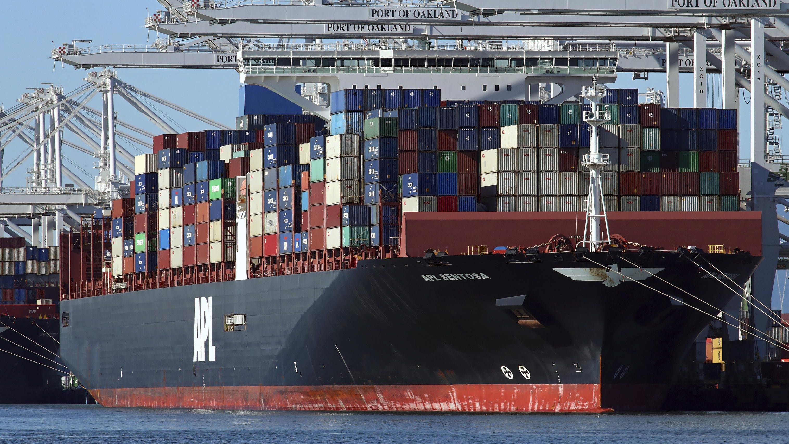 In this Dec. 6, 2018, file photo container ships docked at the Port of Oakland are unloaded in Oakland, Calif. The U.S. trade deficit fell 11.5 percent in November to the lowest level since June.