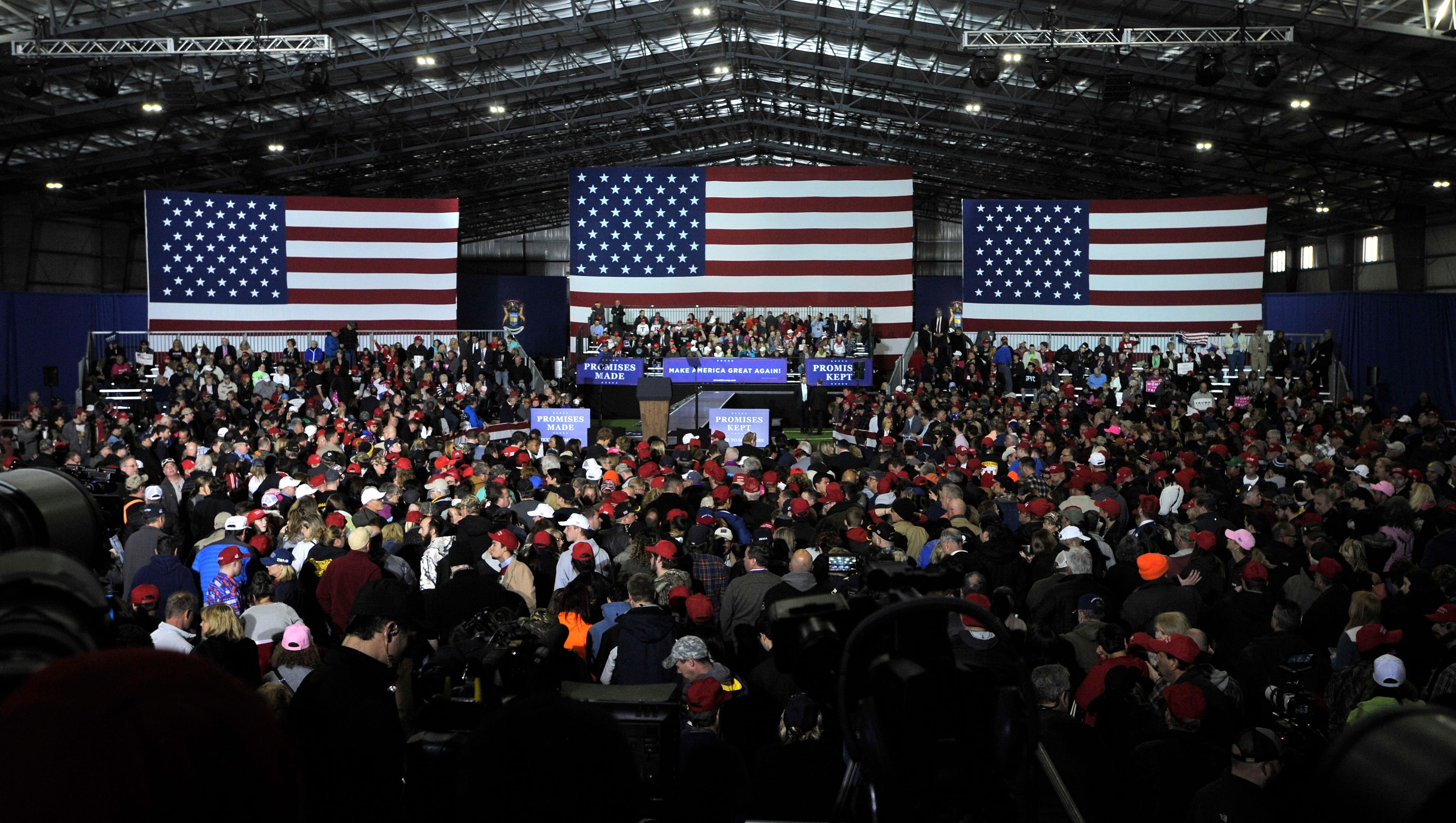 Three huge U.S. flags are the back drop for the president's speech as a capacity crowd fills the Total Sports Park complex in Washington Twp.
