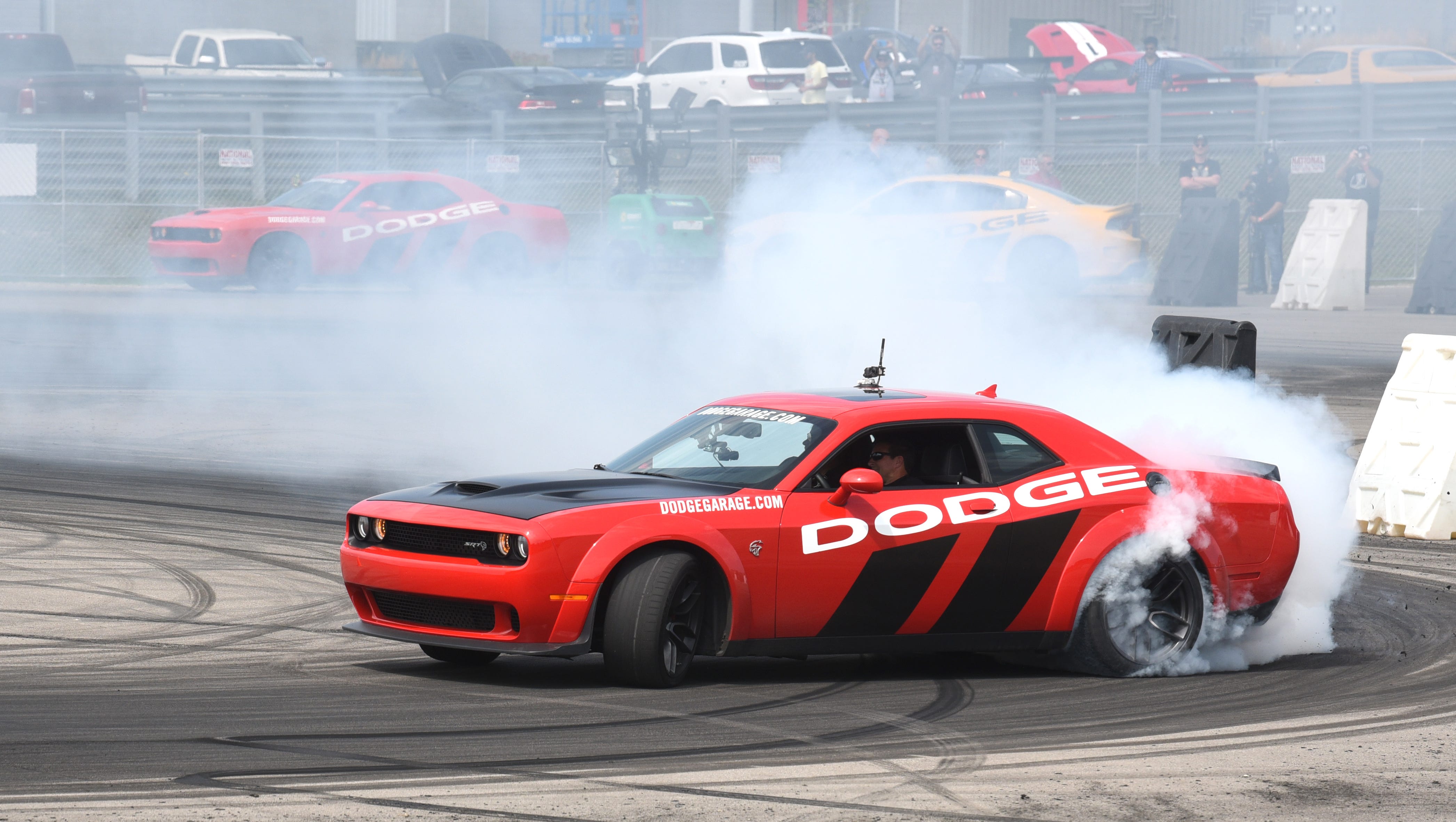 A Dodge Challenger hellcat performs a burnout at the Dodge drift rides demonstration during the Roadkill Nights event held at M1 Concourse in Pontiac on Saturday, August 11, 2018